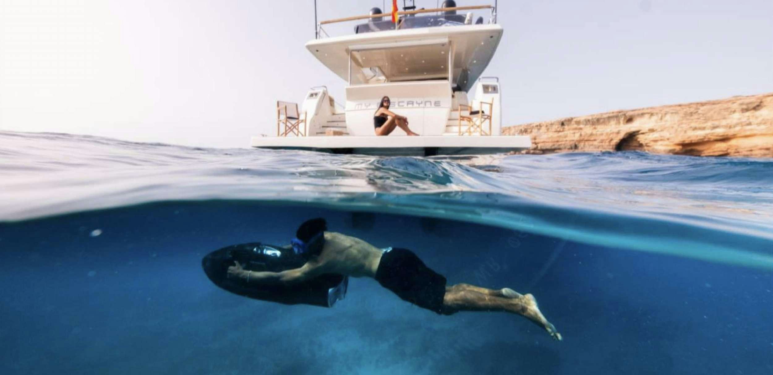 a person swimming in a pool next to a boat aboard BISCAYNE Yacht for Charter