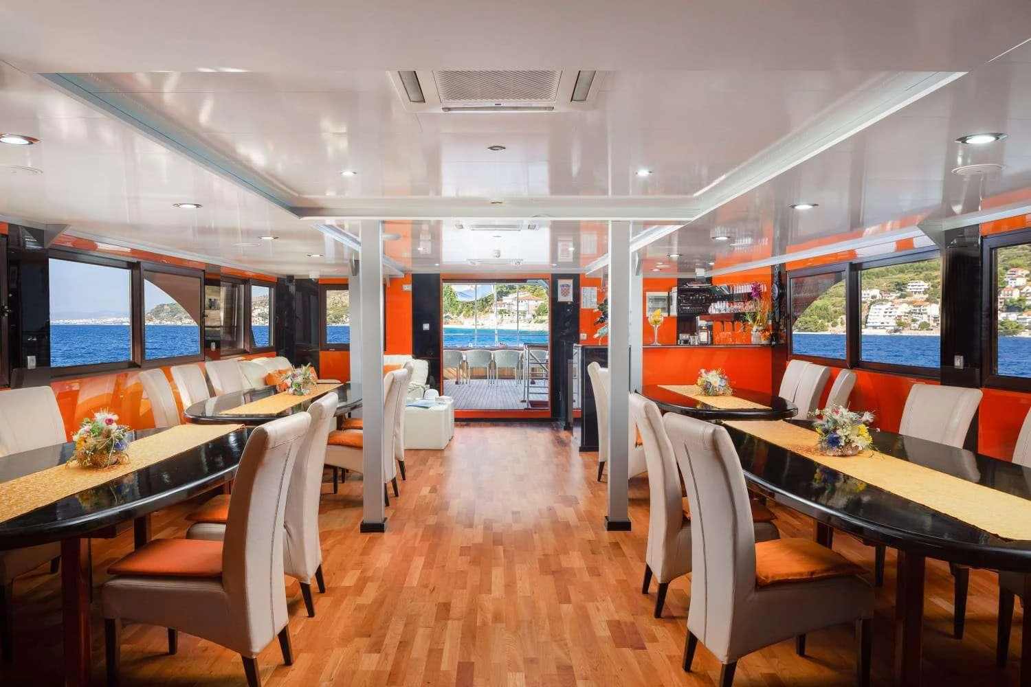 a room with tables and chairs aboard AMALIA Yacht for Charter