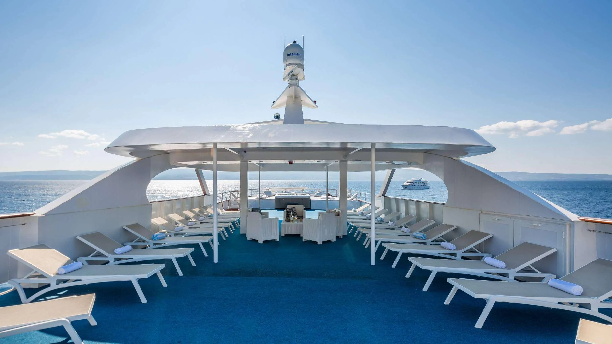 a pool with lounge chairs and a lighthouse on a sunny day aboard AMALIA Yacht for Charter