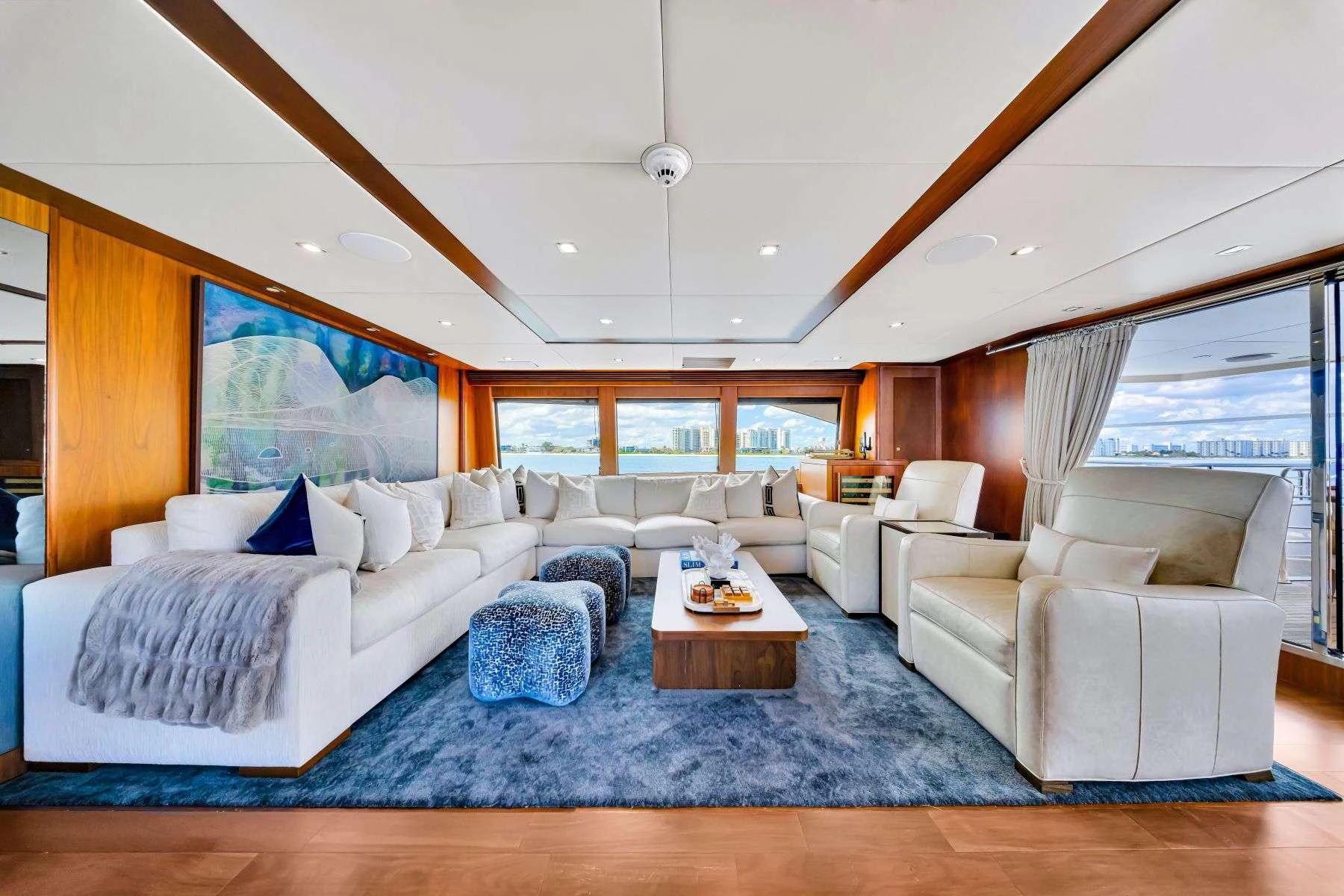 a living room with a large blue rug and white couches aboard NATURAL 9 Yacht for Charter
