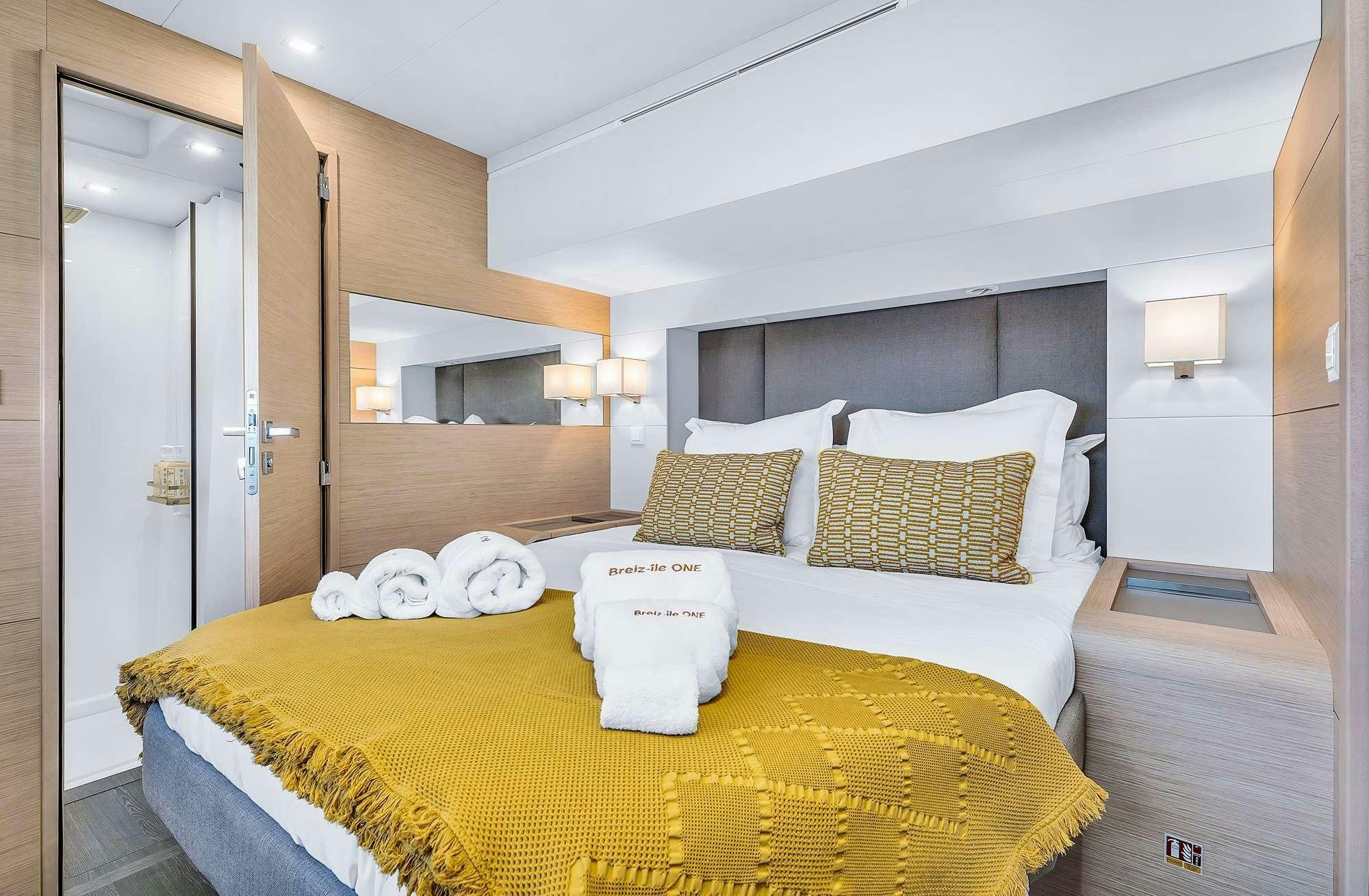 a bedroom with a bed and a mirror aboard ALEGRIA 67 Yacht for Charter