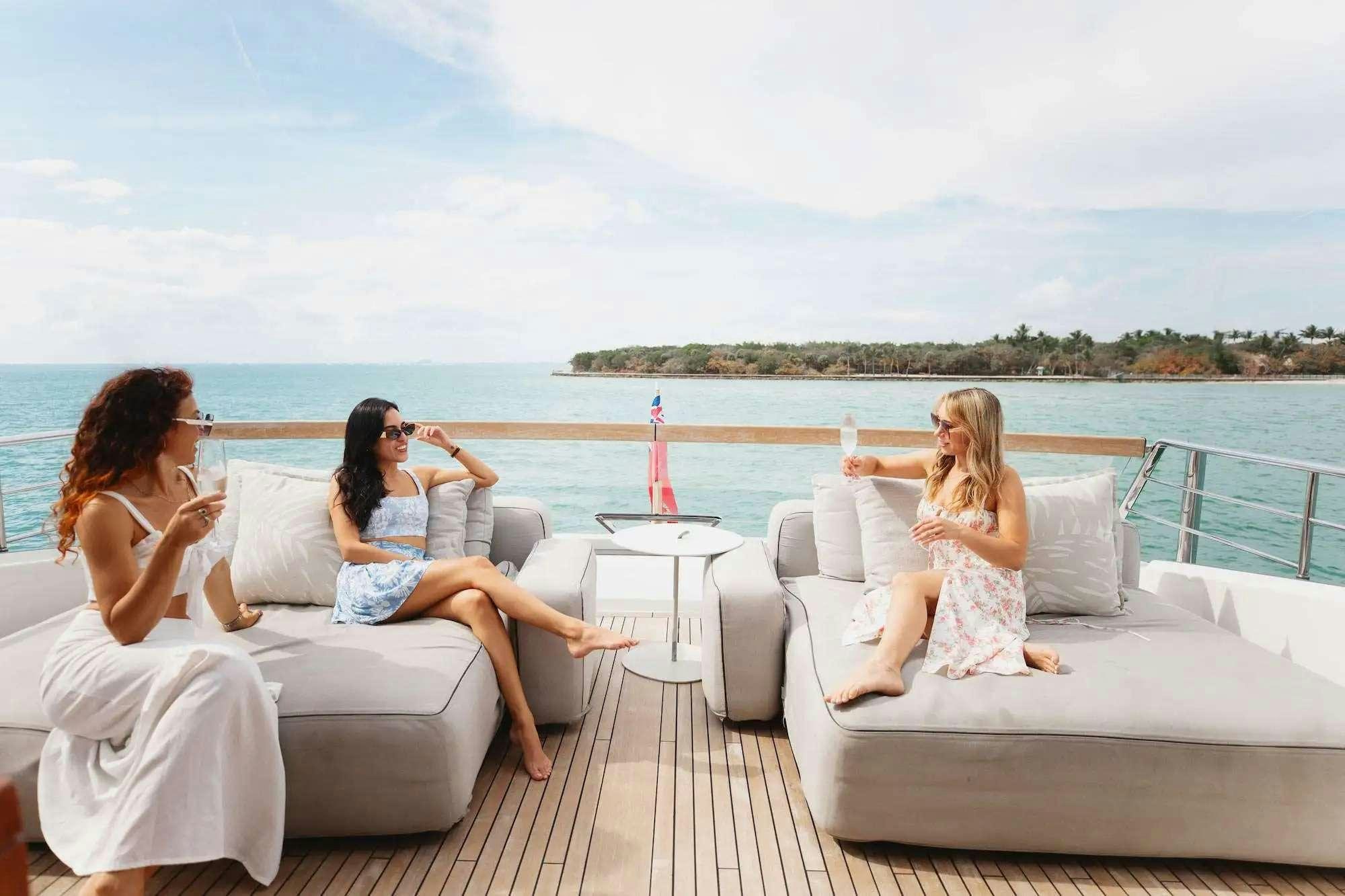 a group of people sitting on a couch on a deck overlooking the ocean aboard 2019 SANLORENZO SX76 #16 Yacht for Charter