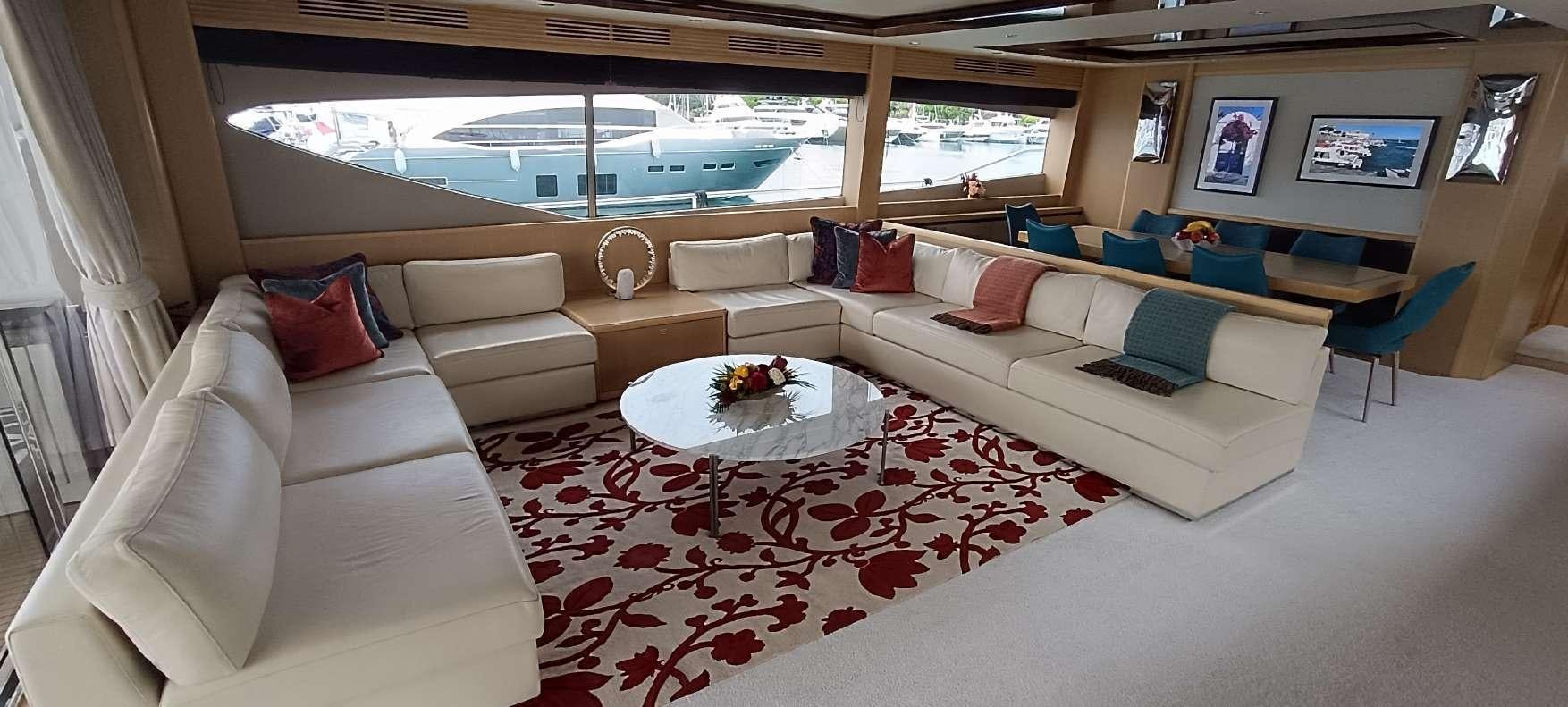a living room with a large white couch and a large window aboard BLUE EYES Yacht for Charter