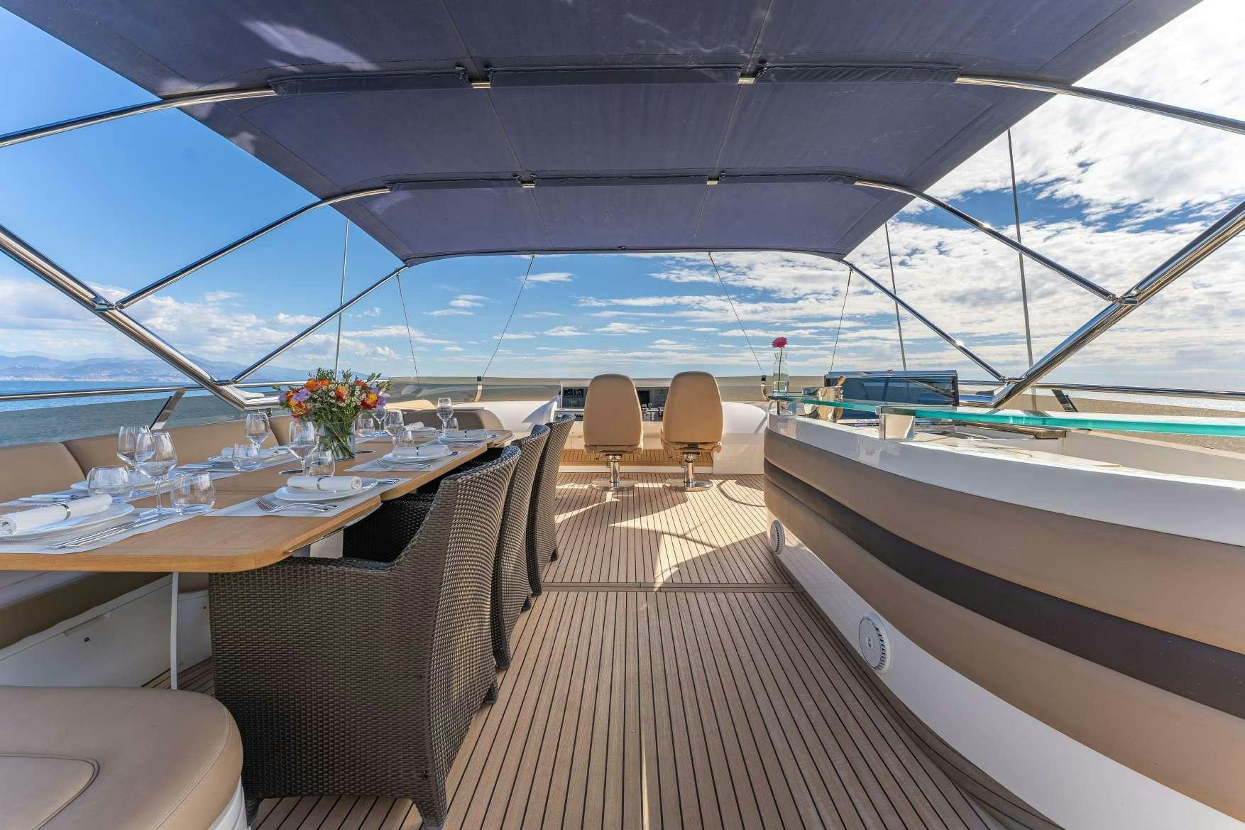 a deck with a table and chairs aboard BLUE EYES Yacht for Charter