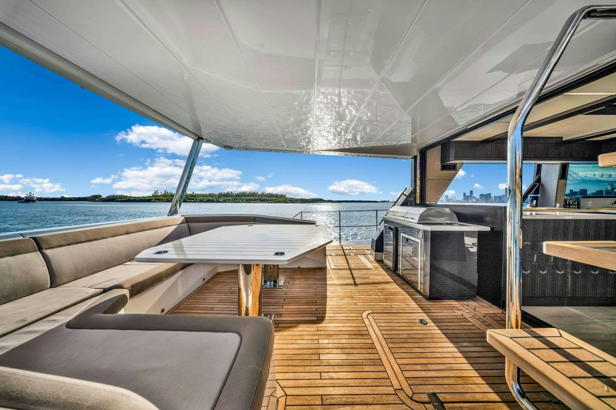 a deck with a large body of water and a boat on it aboard OPTIMUS PRIME Yacht for Charter