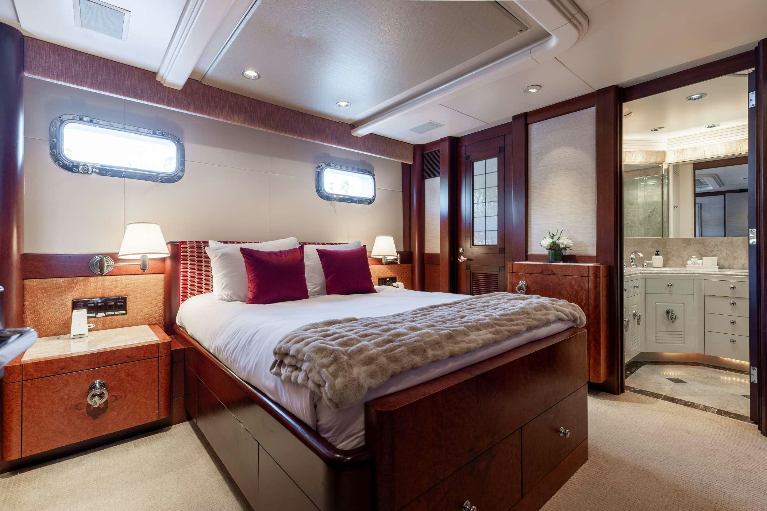 a bedroom with a bed and a dresser aboard LANIDA Yacht for Charter