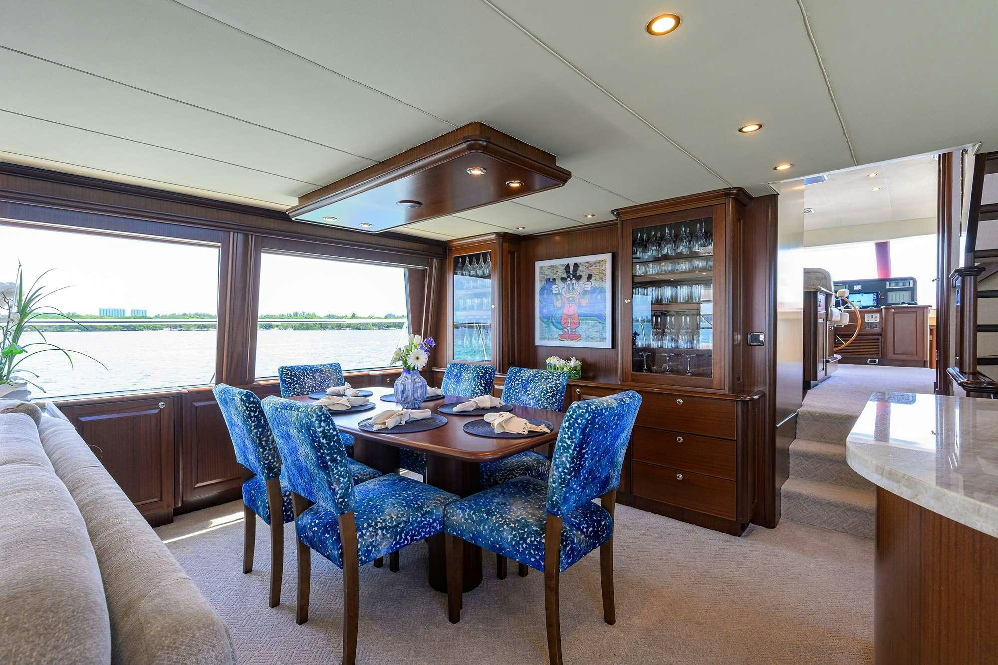 a dining room with a kitchen and a large window aboard JULE Yacht for Charter