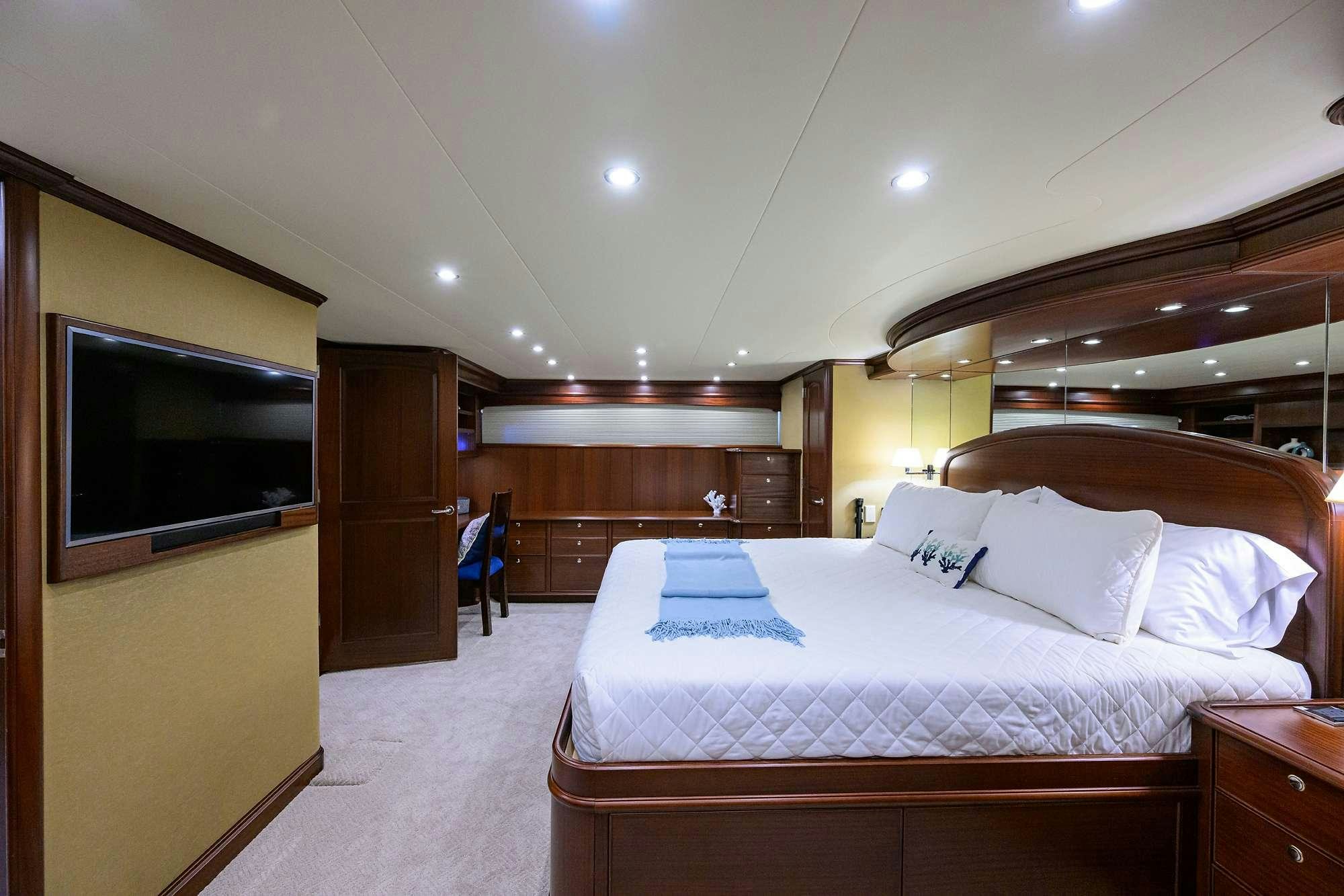 a room with a bed and a television aboard JULE Yacht for Charter