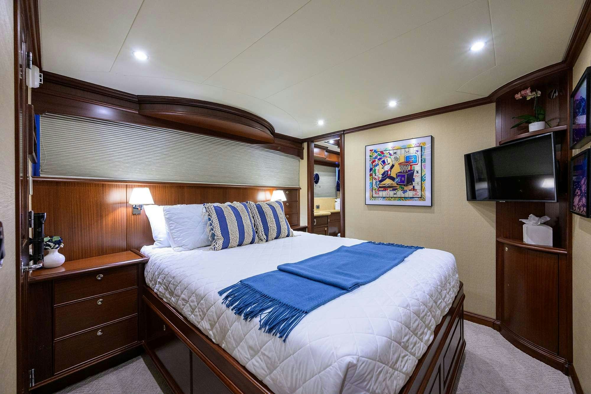 a bedroom with a bed and a television aboard JULE Yacht for Charter