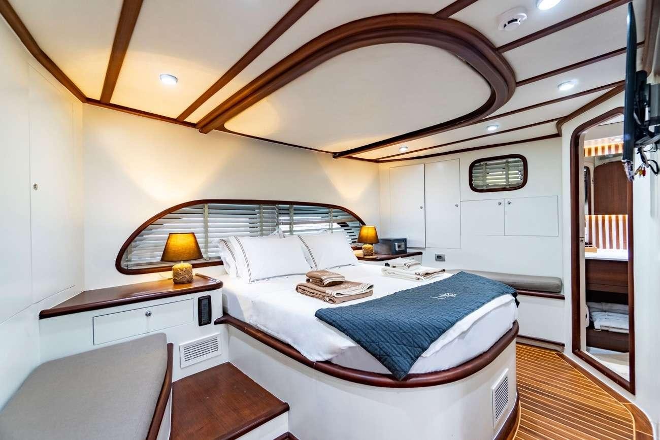 a bedroom with a bed and a desk aboard LUJA Yacht for Charter