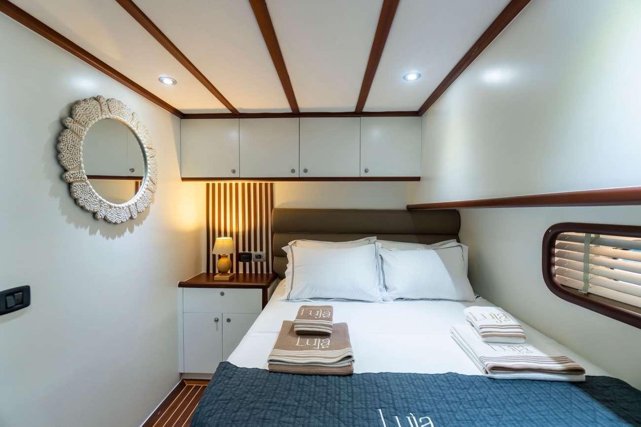 a bed with a mirror above it aboard LUJA Yacht for Charter