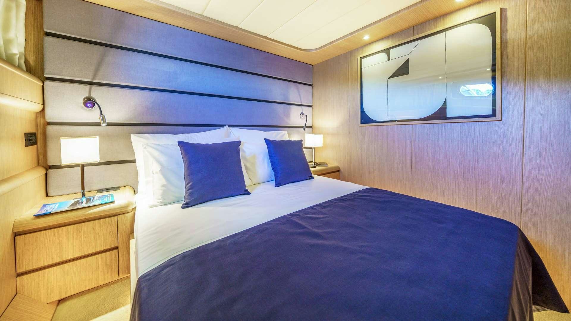 a bed with a blue and white bed spread aboard PHANTOM Yacht for Charter