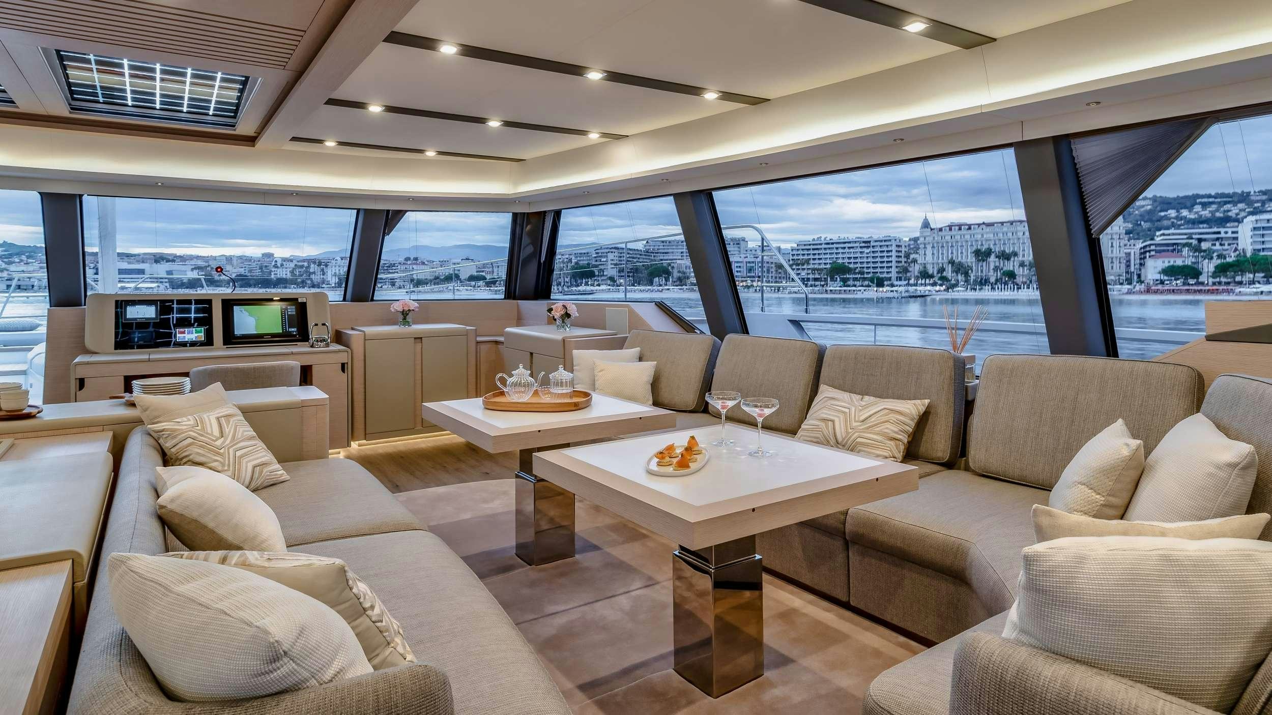 a living room with a large window aboard CHRISTAL MIO 80 Yacht for Charter