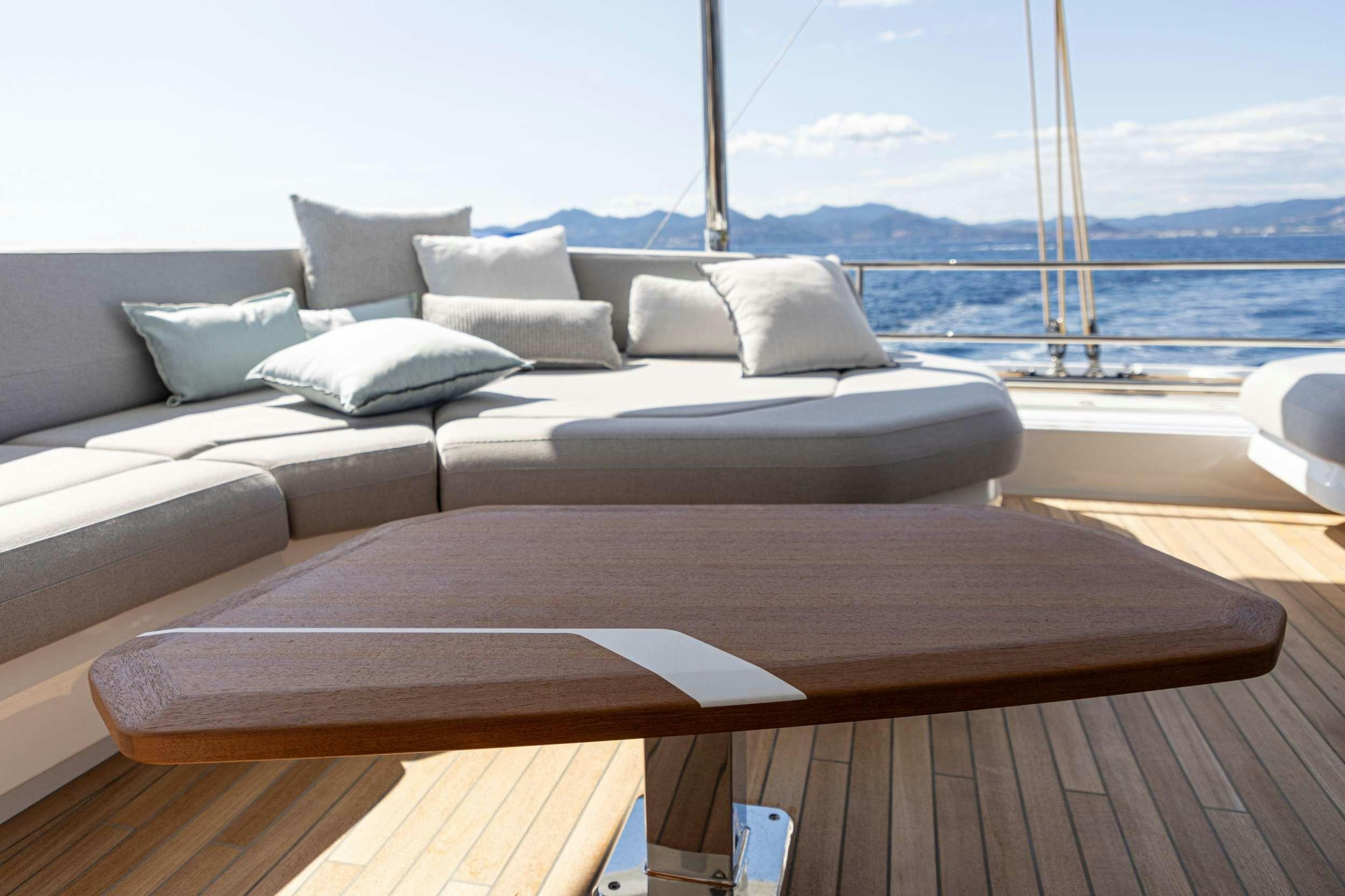 a couch with a table on it aboard CHRISTAL MIO 80 Yacht for Charter