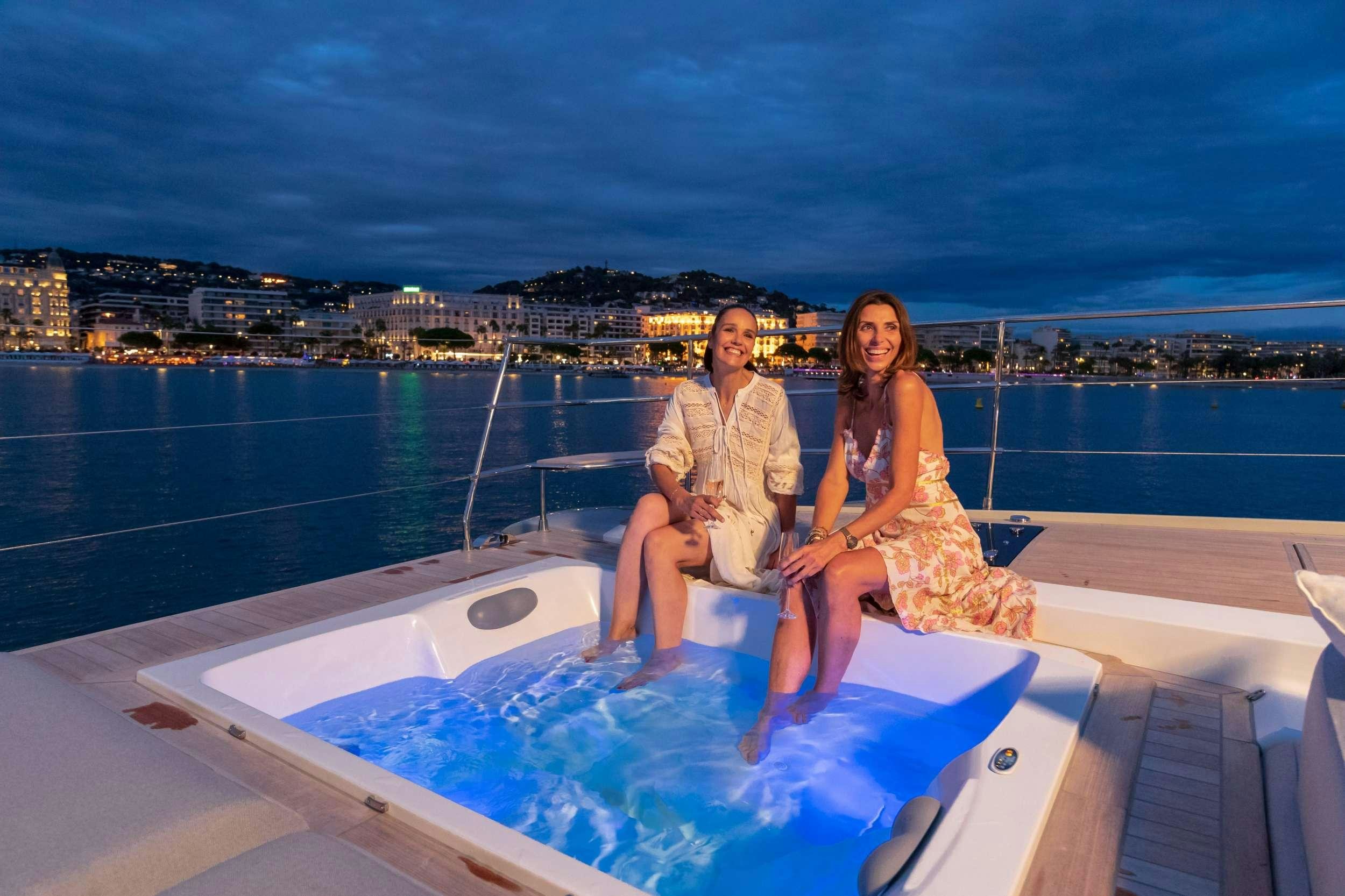 a man and woman sitting on a boat in the water aboard CHRISTAL MIO 80 Yacht for Charter