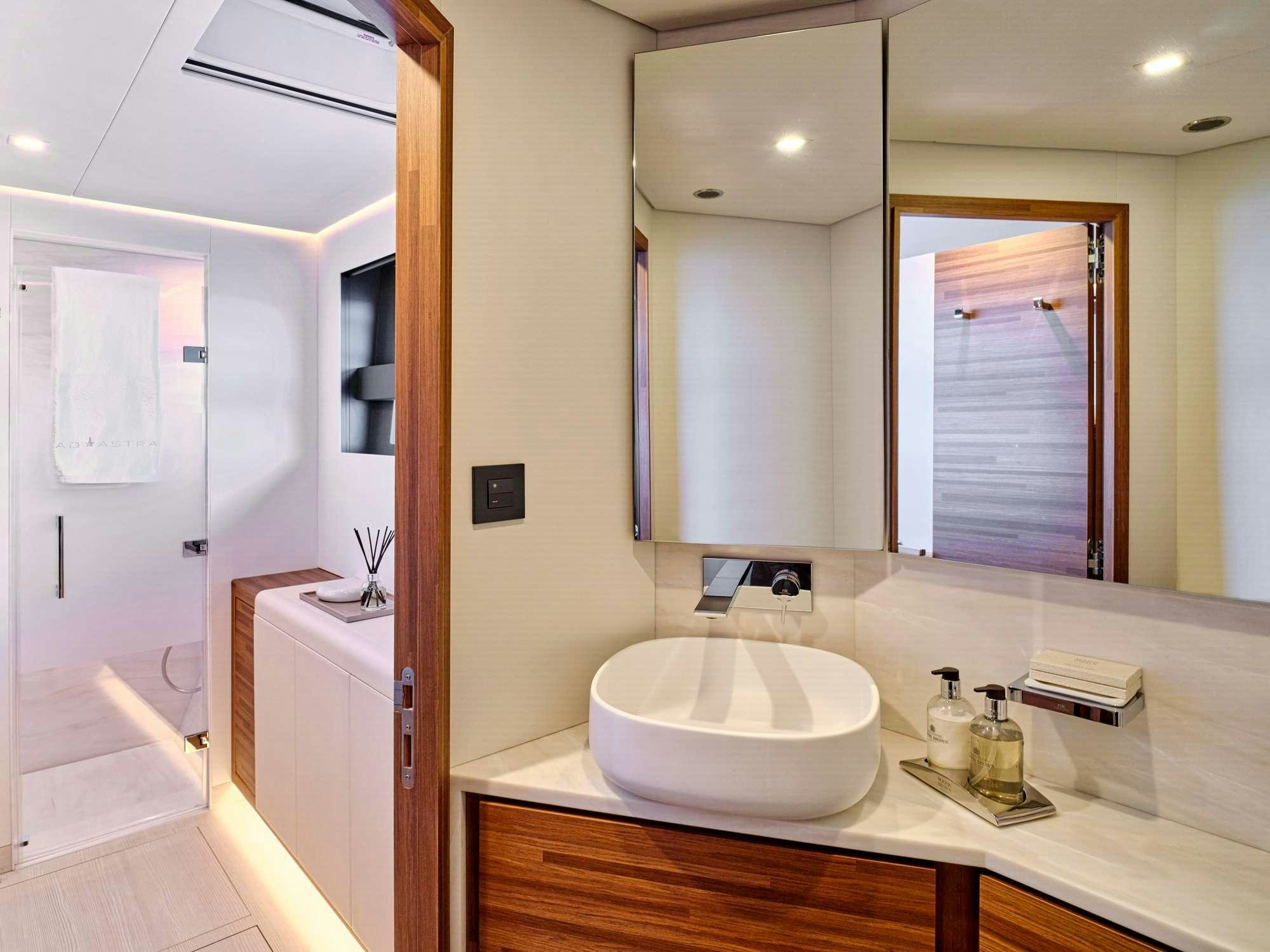 a bathroom with a sink and mirrors aboard CHRISTAL MIO 80 Yacht for Charter