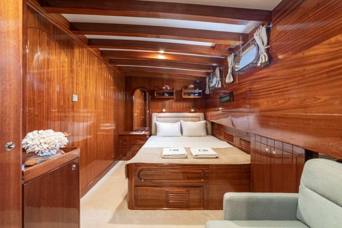 a room with a bed and a couch aboard TORINI Yacht for Charter