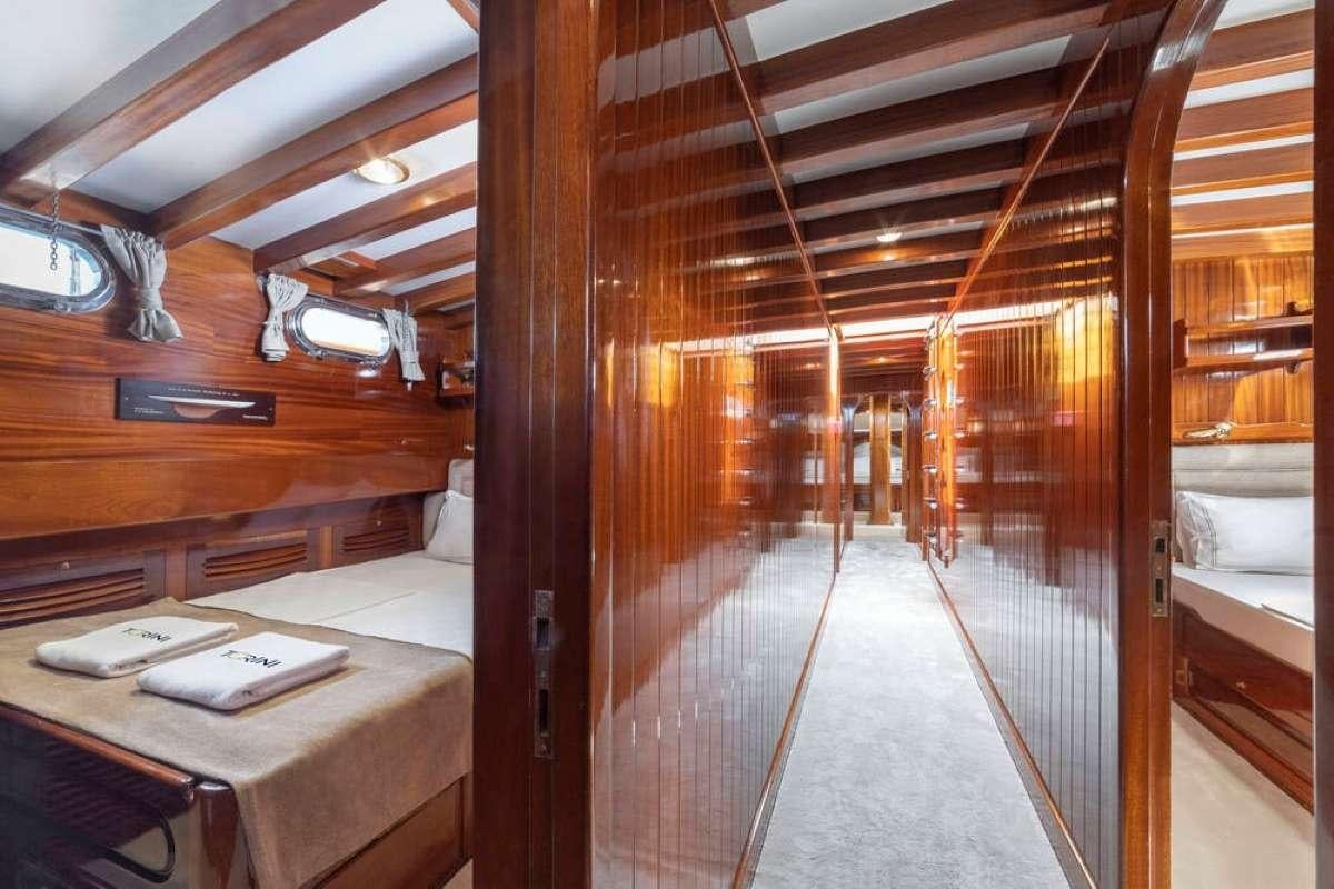 a room with a bed and desk aboard TORINI Yacht for Charter