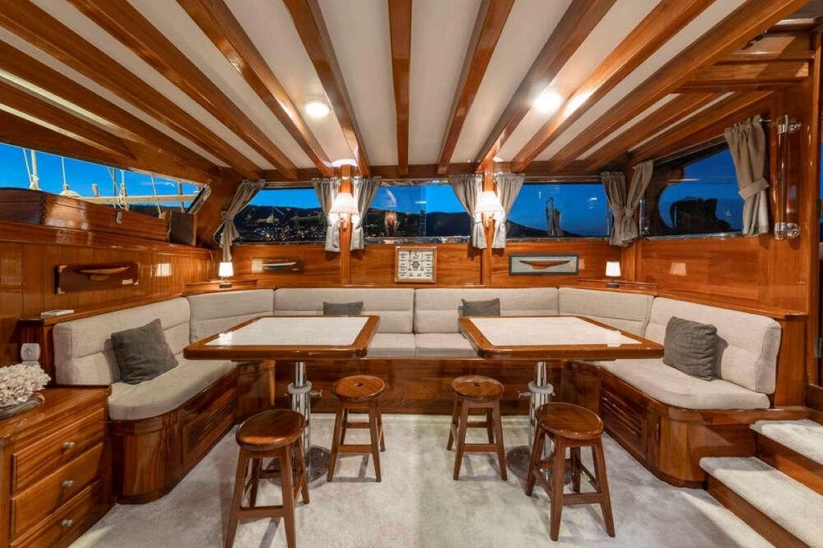 a room with a bed and a couch and a table aboard TORINI Yacht for Charter