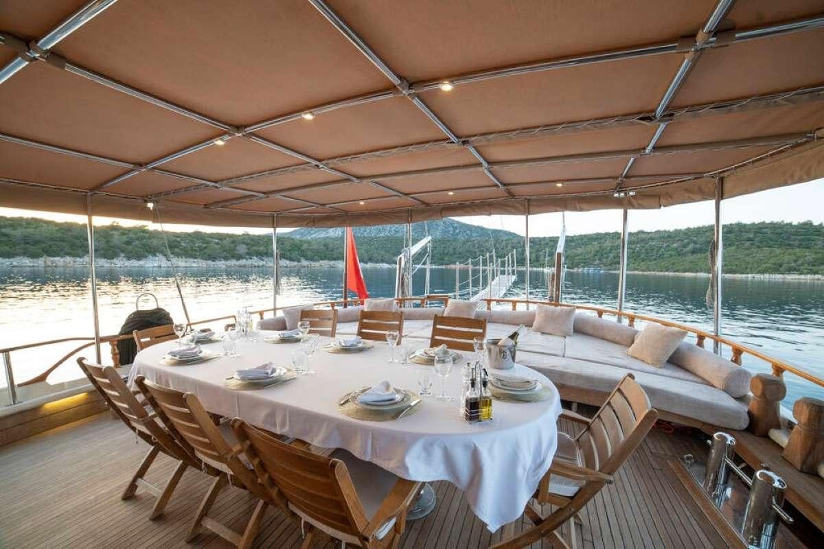 a table set for a meal on a deck aboard TORINI Yacht for Charter