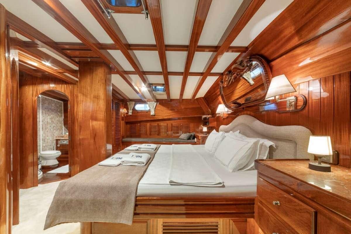 a bed with a wood ceiling aboard TORINI Yacht for Charter
