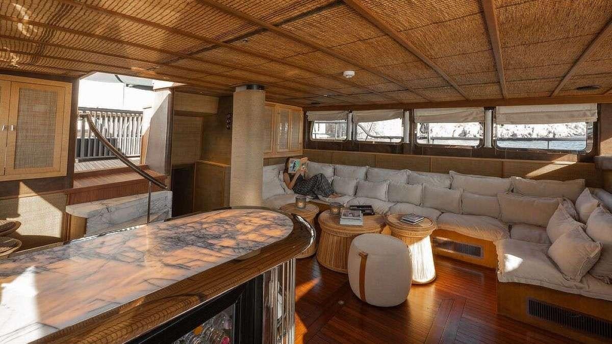 a living room with a large sofa and a table aboard MY LOVER Yacht for Charter