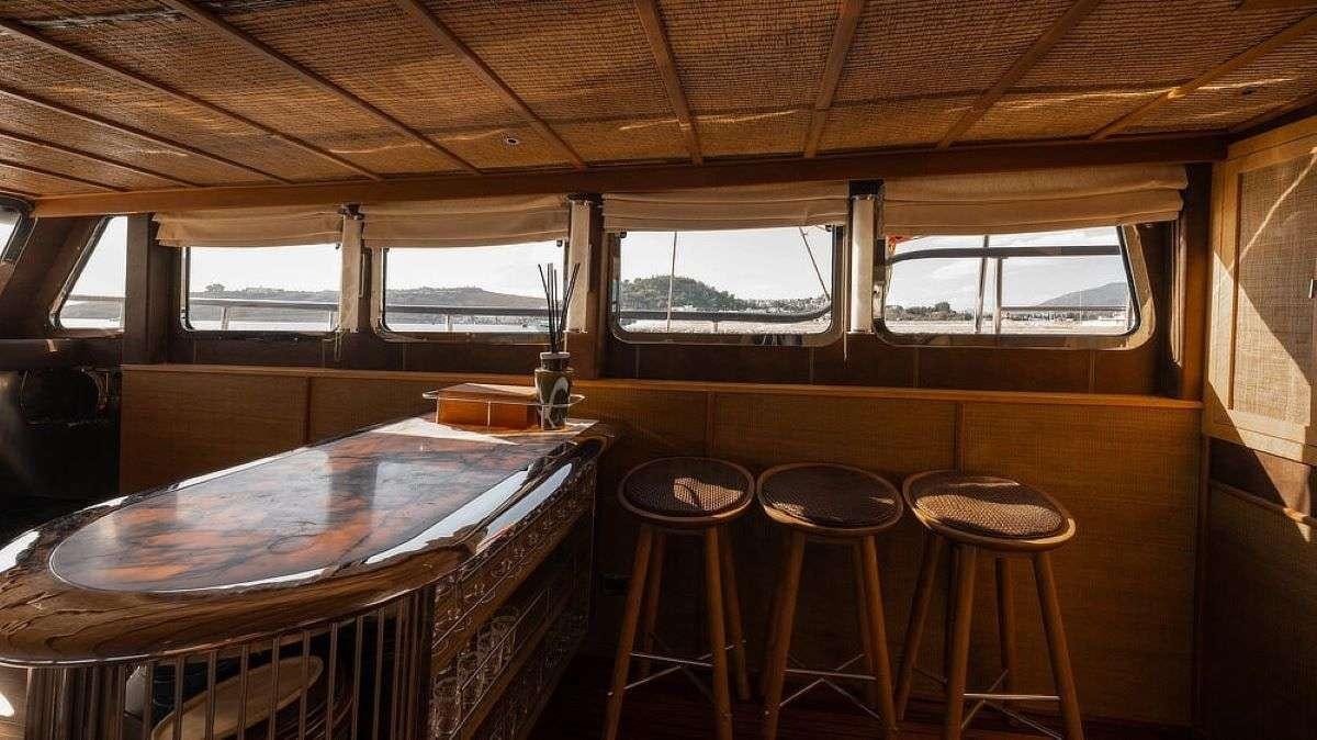 a room with a table and stools aboard MY LOVER Yacht for Charter