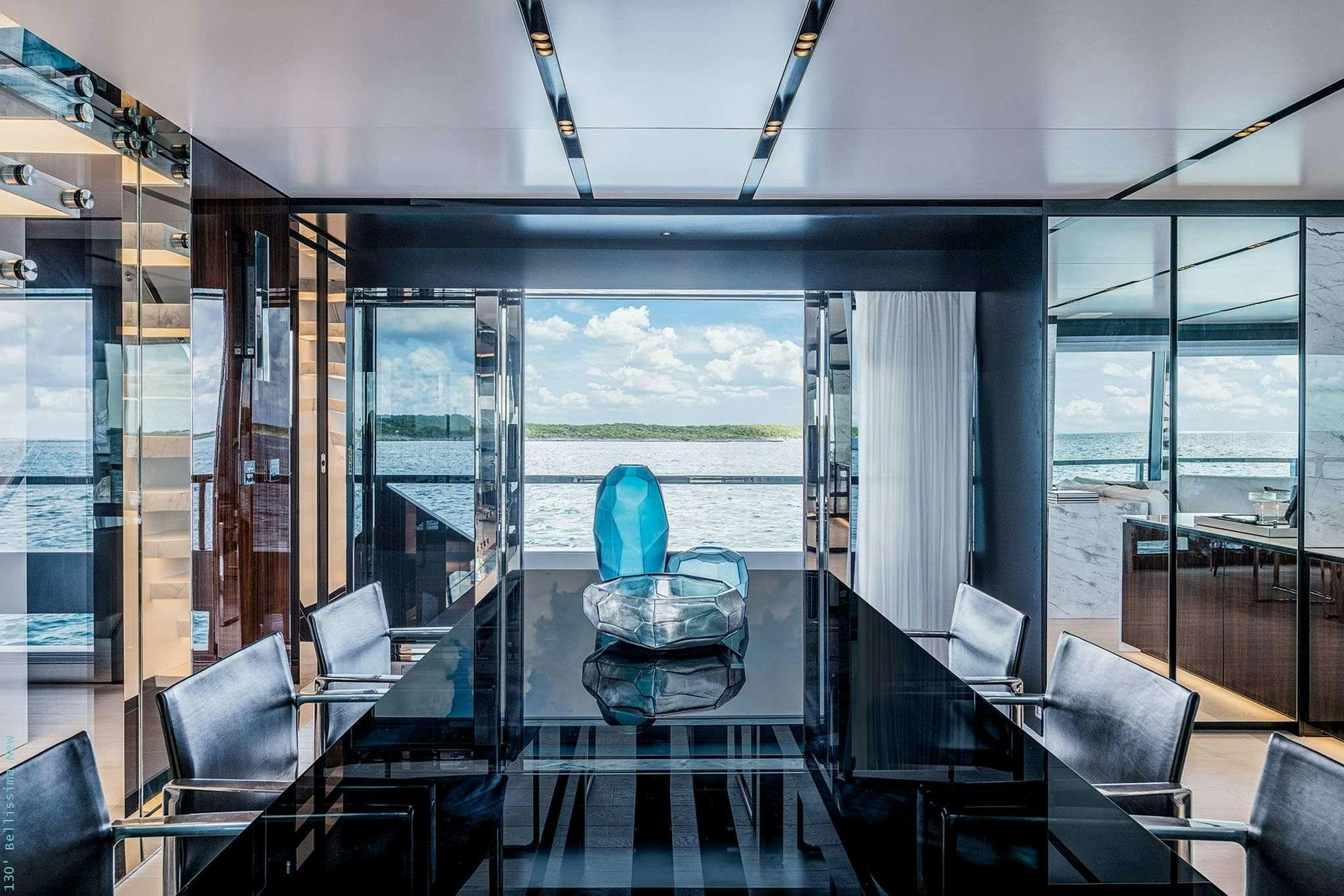 a room with a large glass wall and a large window with a view of the ocean aboard TASTY WAVES Yacht for Charter