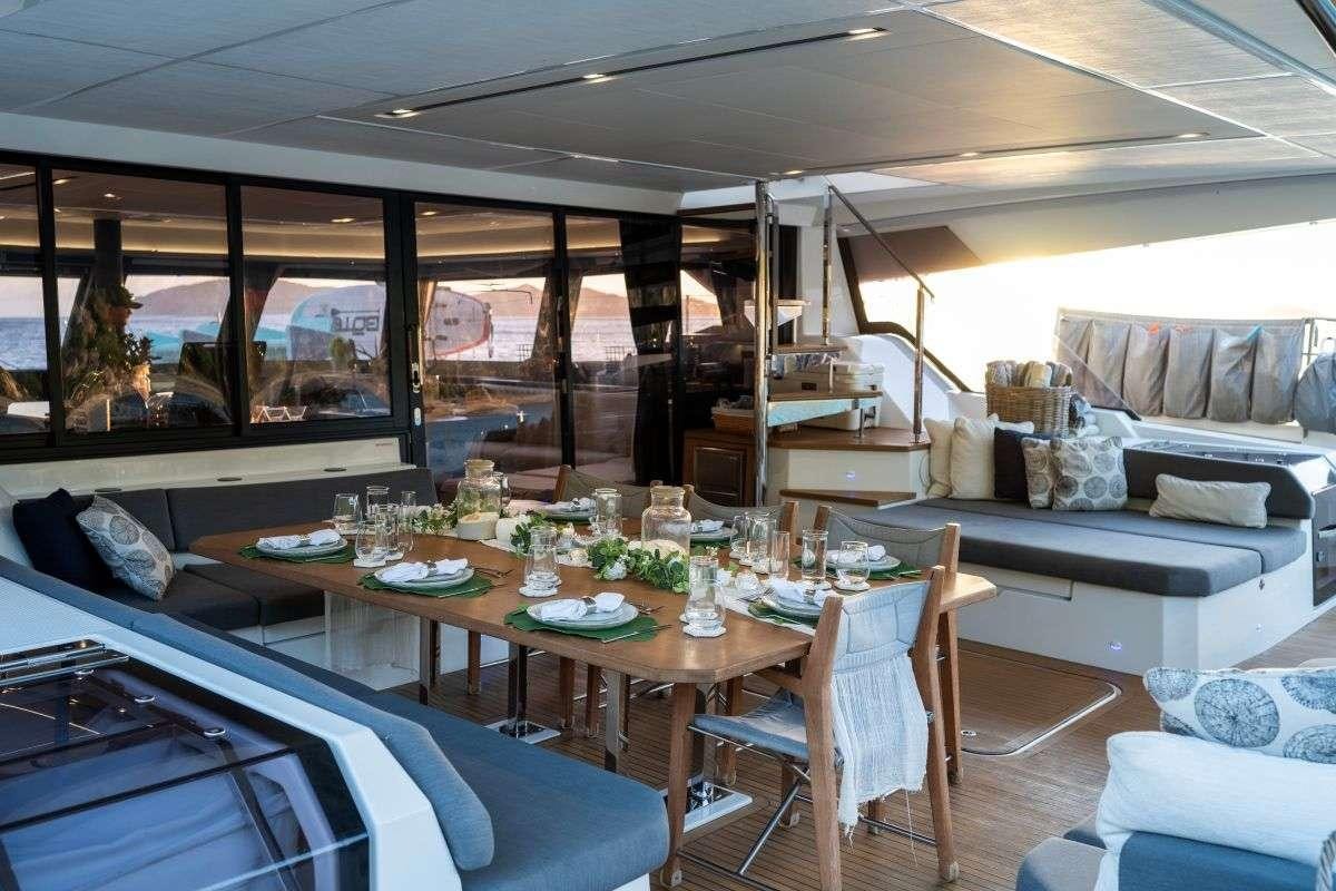 a large living room with a large table and chairs aboard LYRA Yacht for Charter