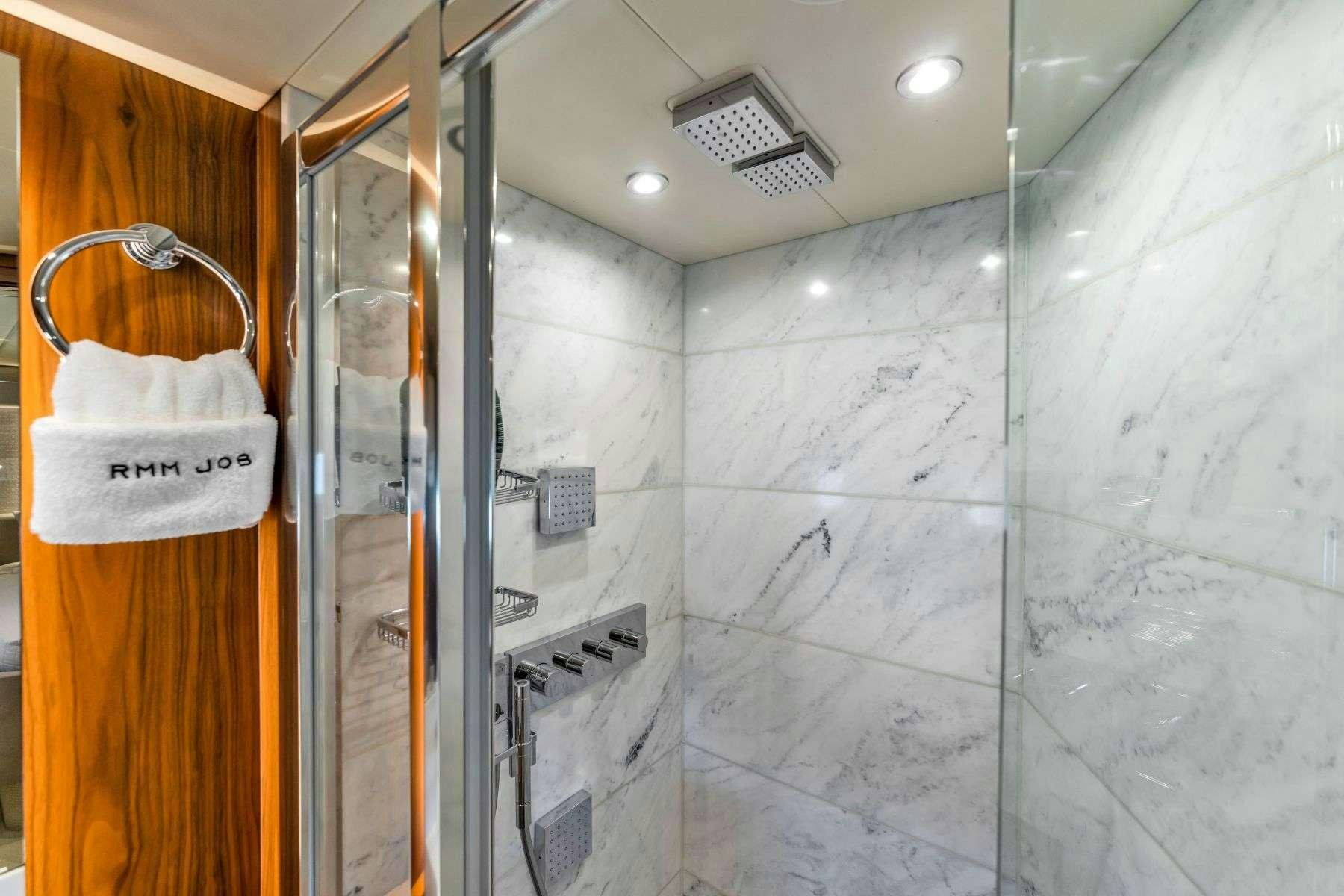 a shower with a tile floor aboard RMM JOB Yacht for Charter