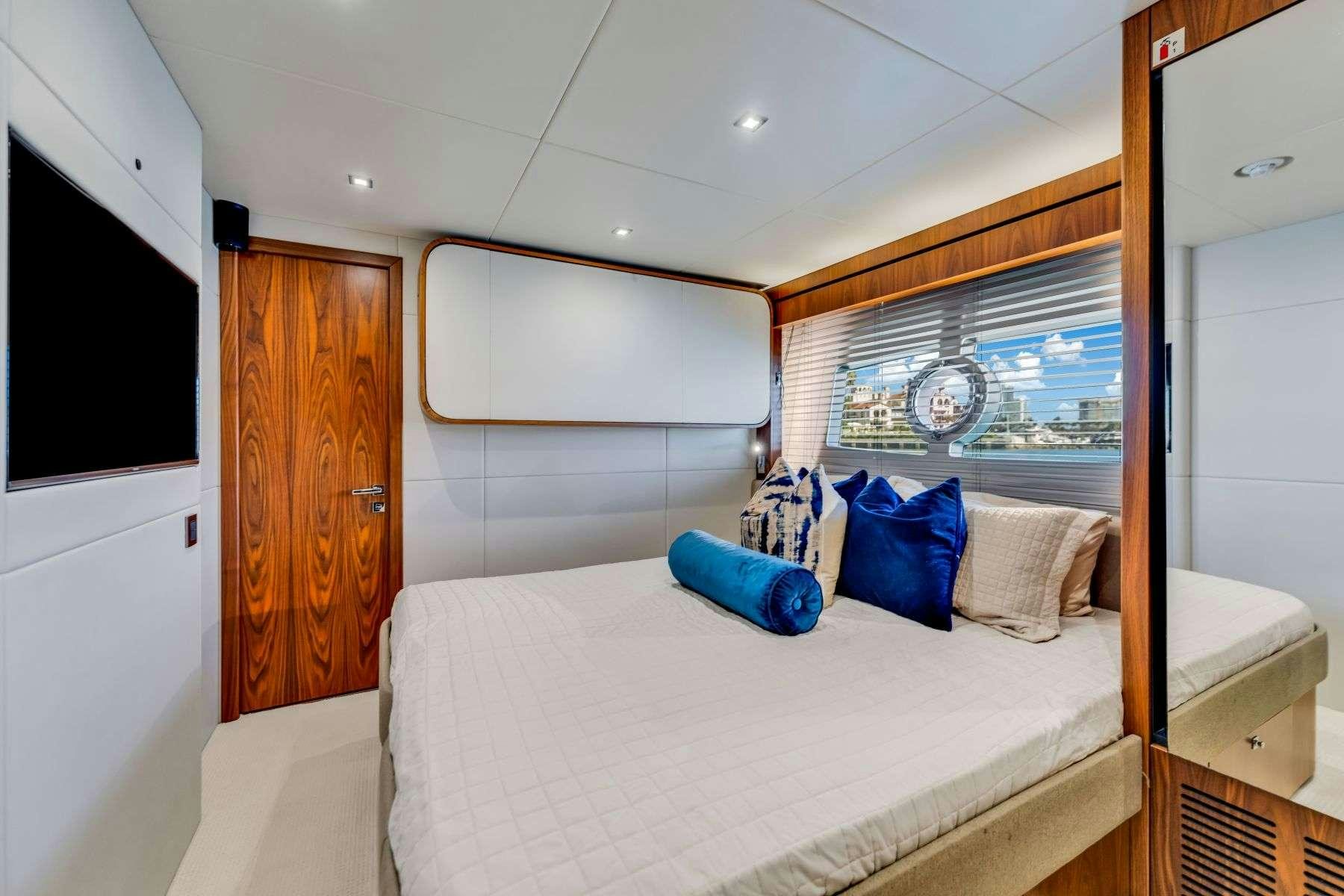 a bedroom with a bed and a television aboard RMM JOB Yacht for Charter