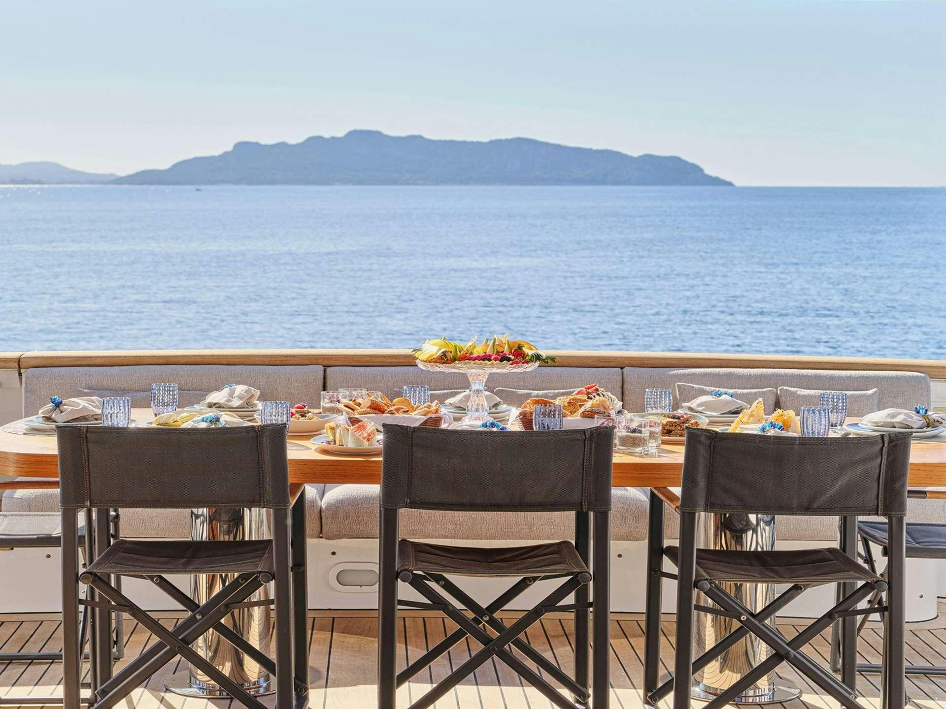 a table with food on it by the water aboard TIGRA Yacht for Charter