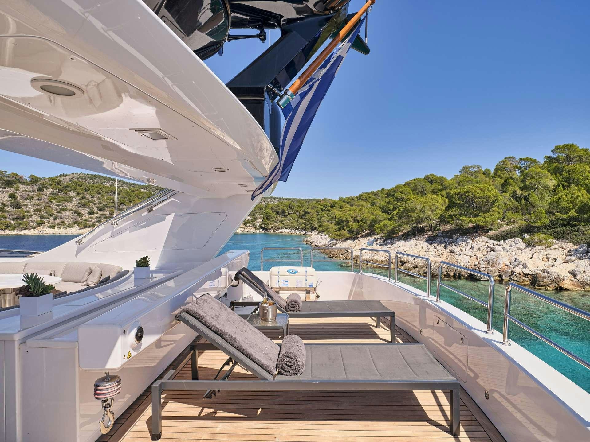 a deck with a railing and a body of water and trees in the background aboard TIGRA Yacht for Charter
