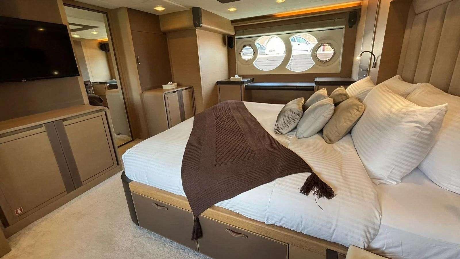 a bed with a brown comforter aboard NAYLA Yacht for Charter