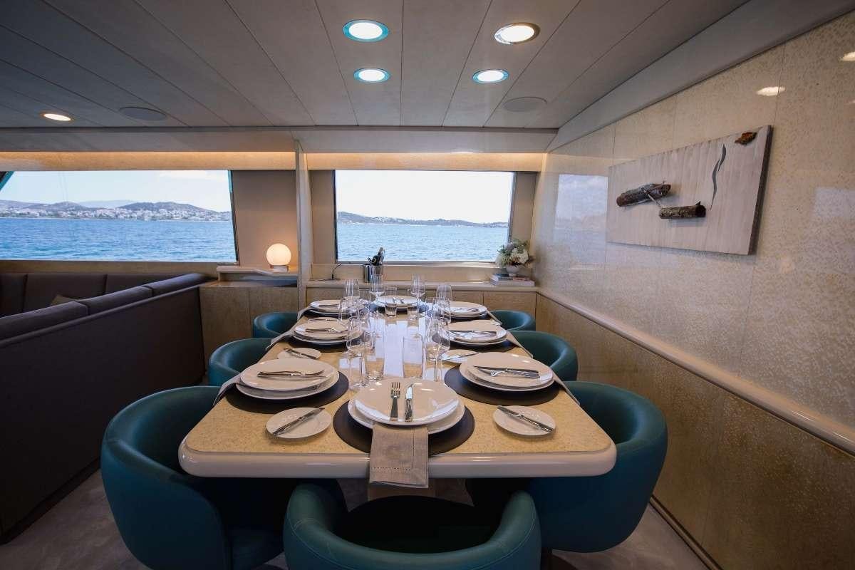 a dining table with plates and chairs aboard CARI&NTILDE;O Yacht for Charter