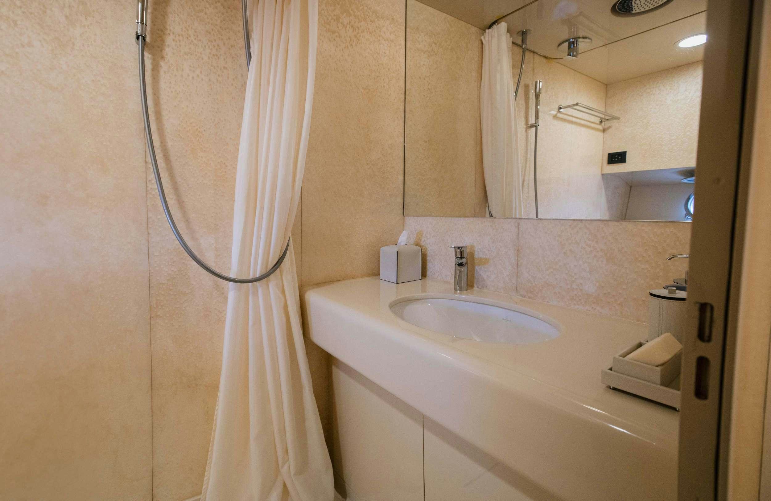 a bathroom with a sink and a shower curtain aboard CARI&NTILDE;O Yacht for Charter