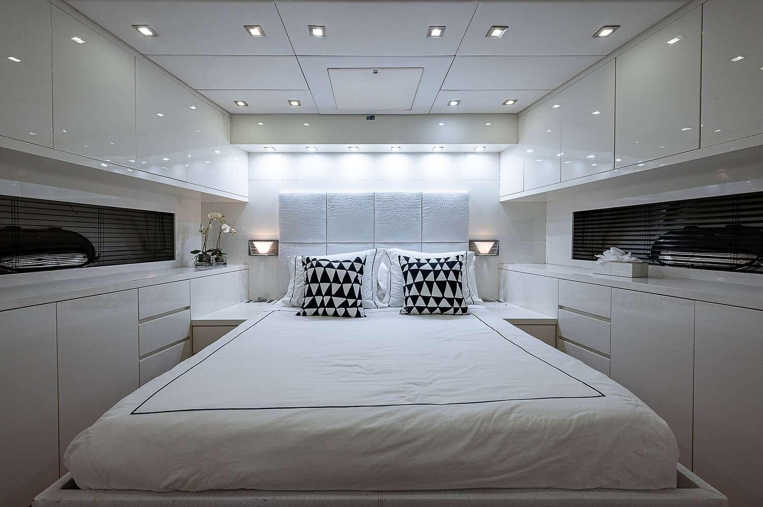 a large white bedroom with a large bed and a black and white wall aboard CASSINELLA Yacht for Charter