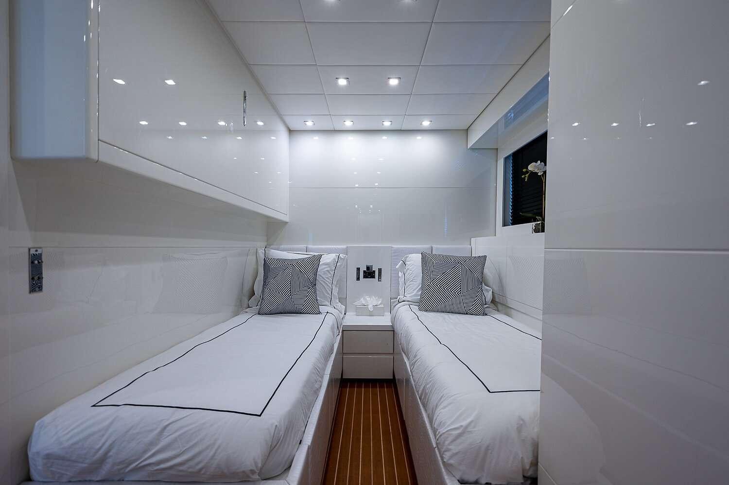a room with white beds aboard CASSINELLA Yacht for Charter