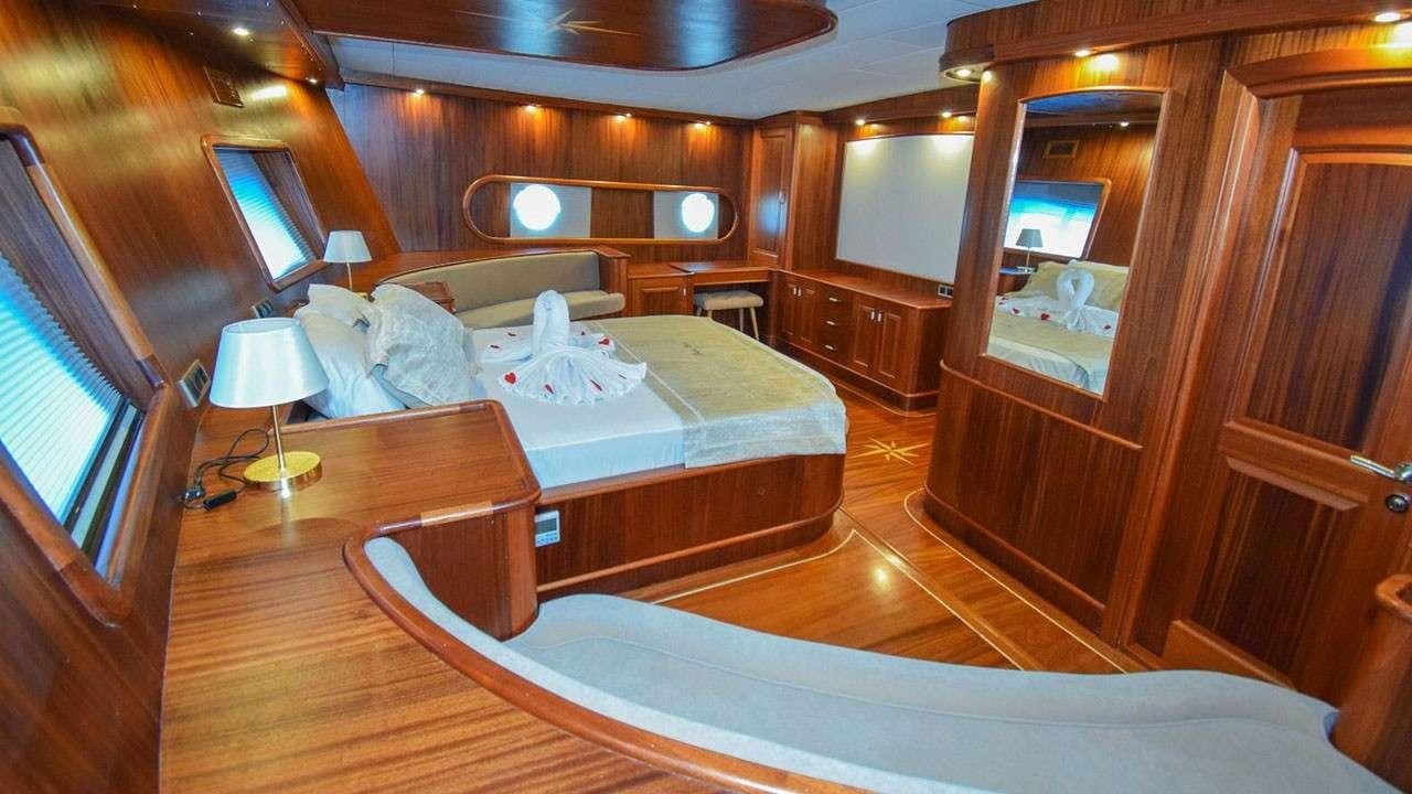 a bedroom with a bed and a desk aboard BABACAN Yacht for Charter