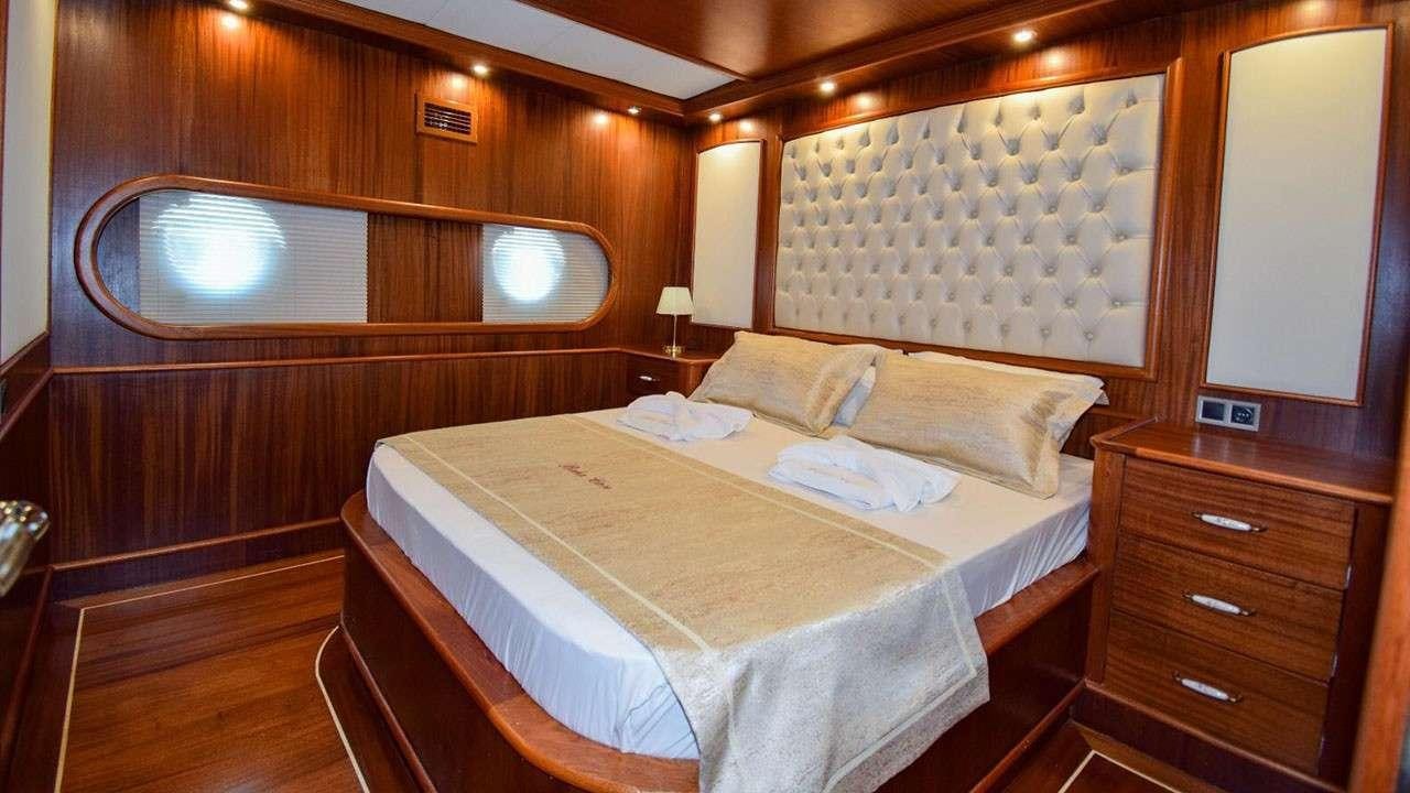 a room with a bed and a dresser aboard BABACAN Yacht for Charter