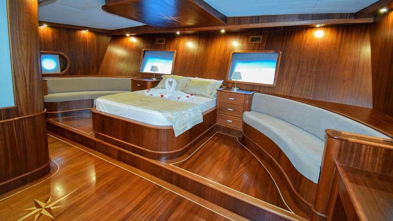 a room with a bed and a television aboard BABACAN Yacht for Charter