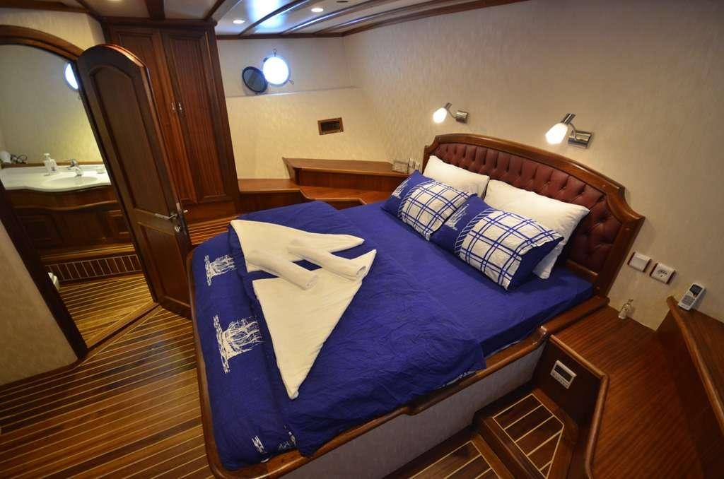 a bed with blue sheets aboard C. TANER 2 Yacht for Charter