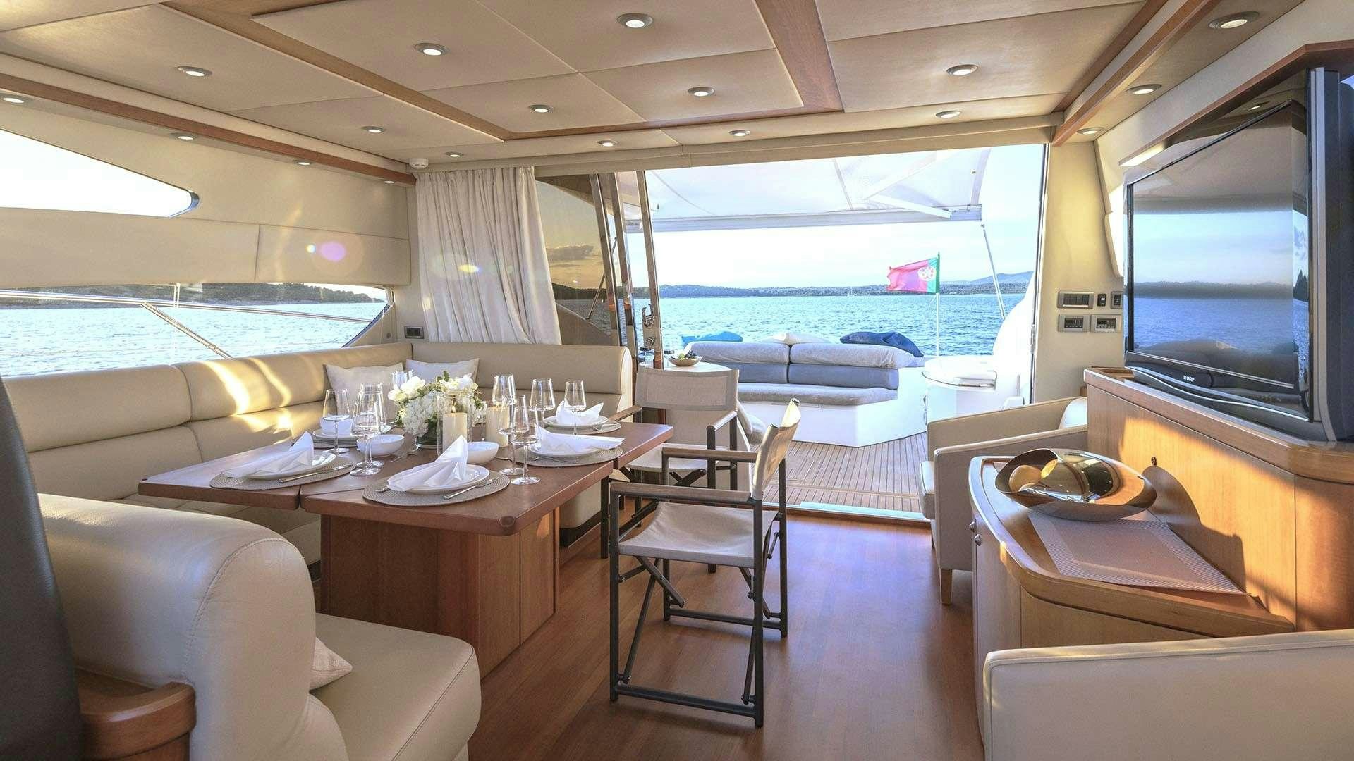 a room with a table chairs and a large window aboard BOY TOY Yacht for Charter