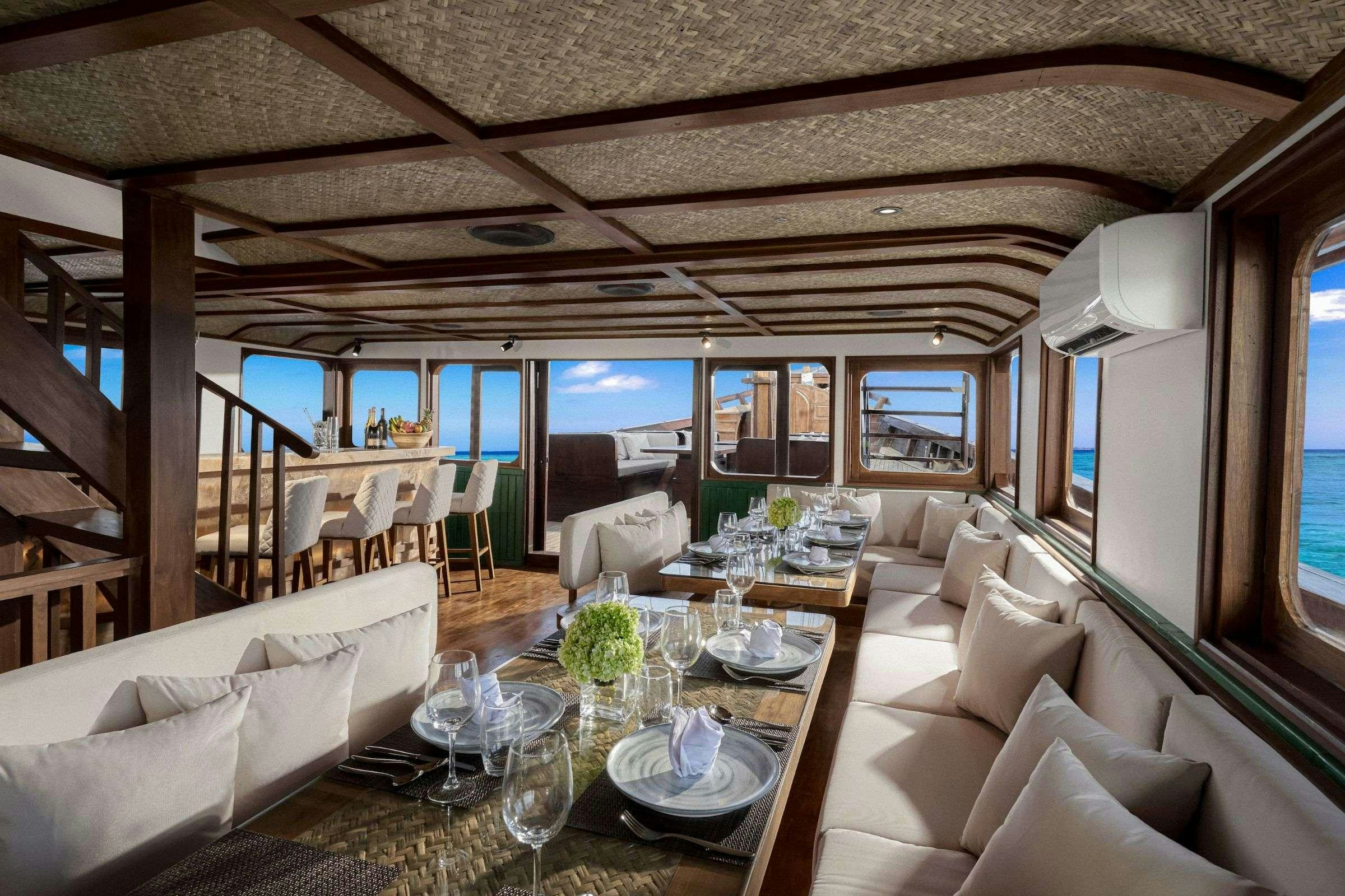 a room with a table chairs and a large window aboard SAMSARA SAMUDRA Yacht for Charter