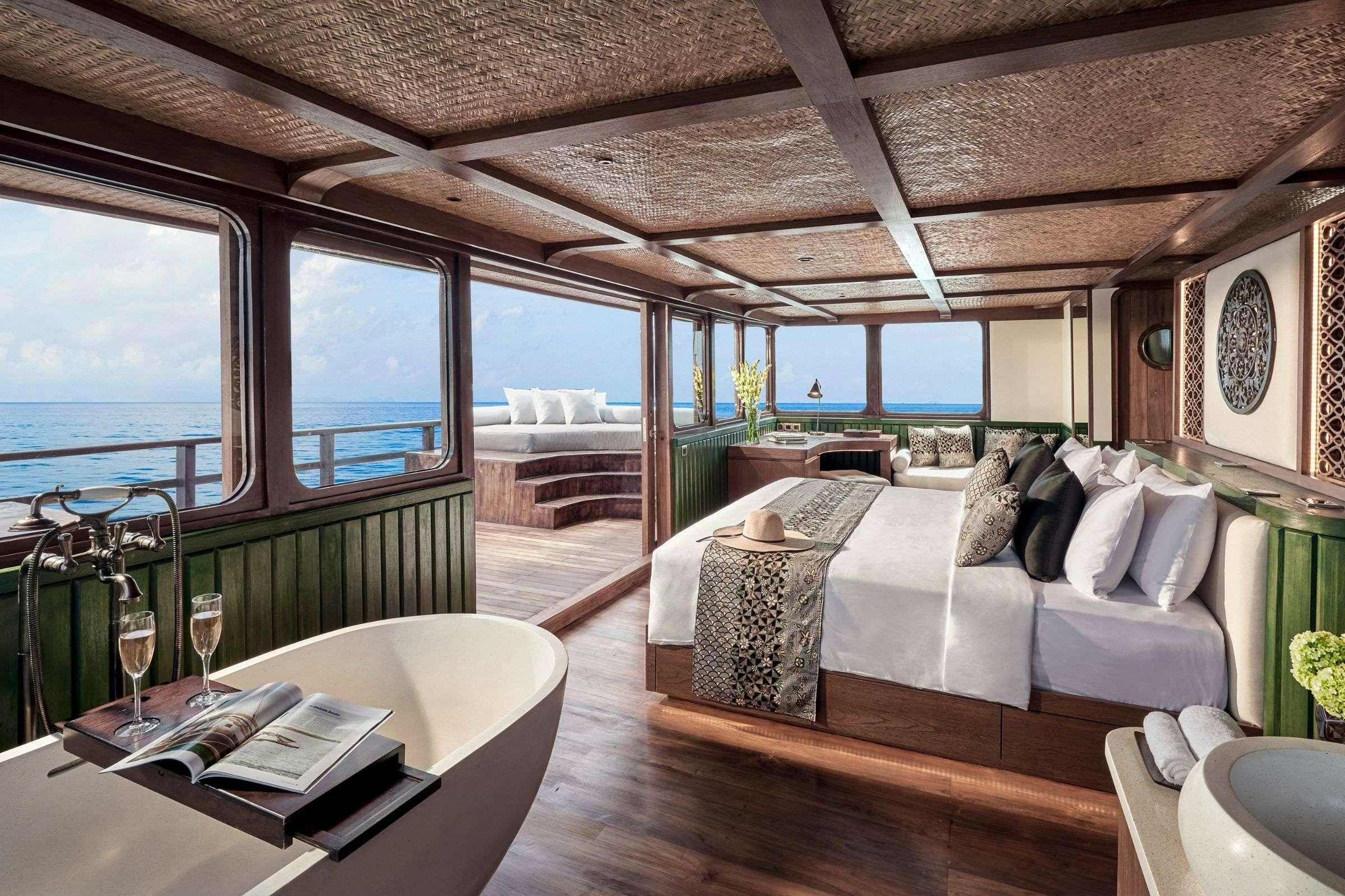 a room with a bed and a table aboard SAMSARA SAMUDRA Yacht for Charter