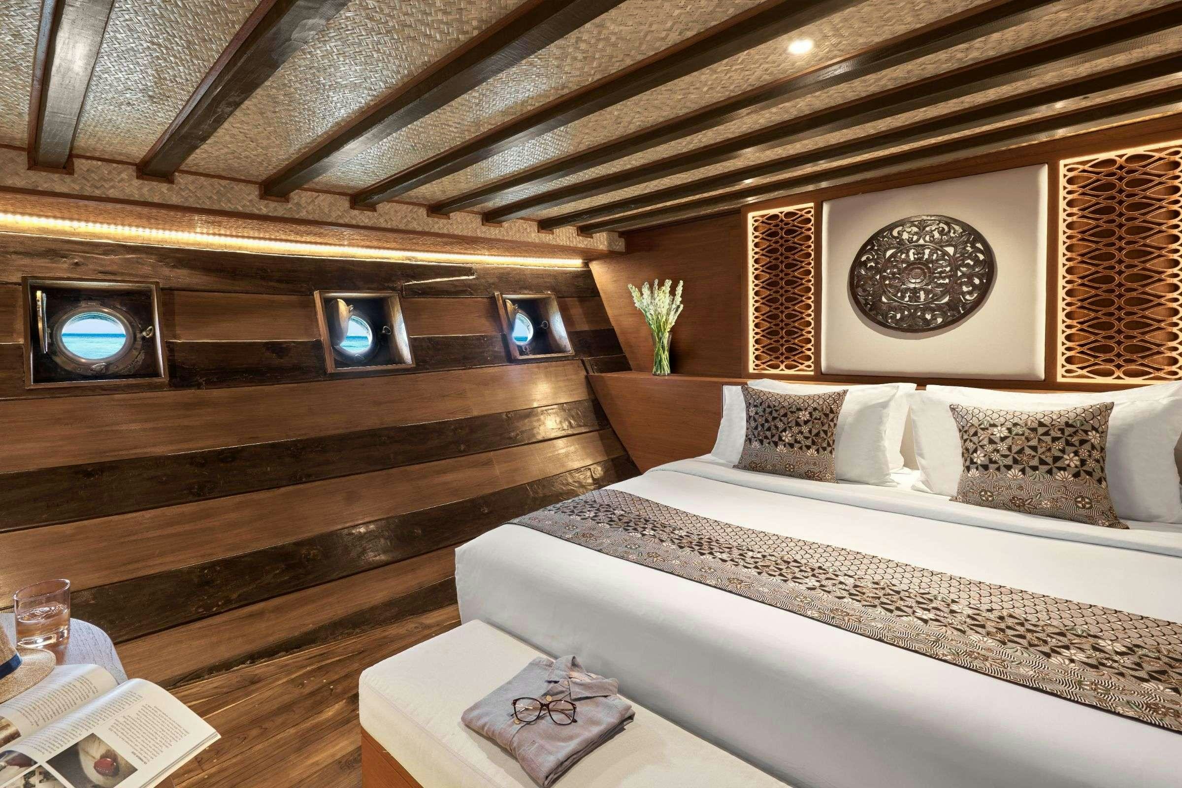a room with a bed and a piano aboard SAMSARA SAMUDRA Yacht for Charter