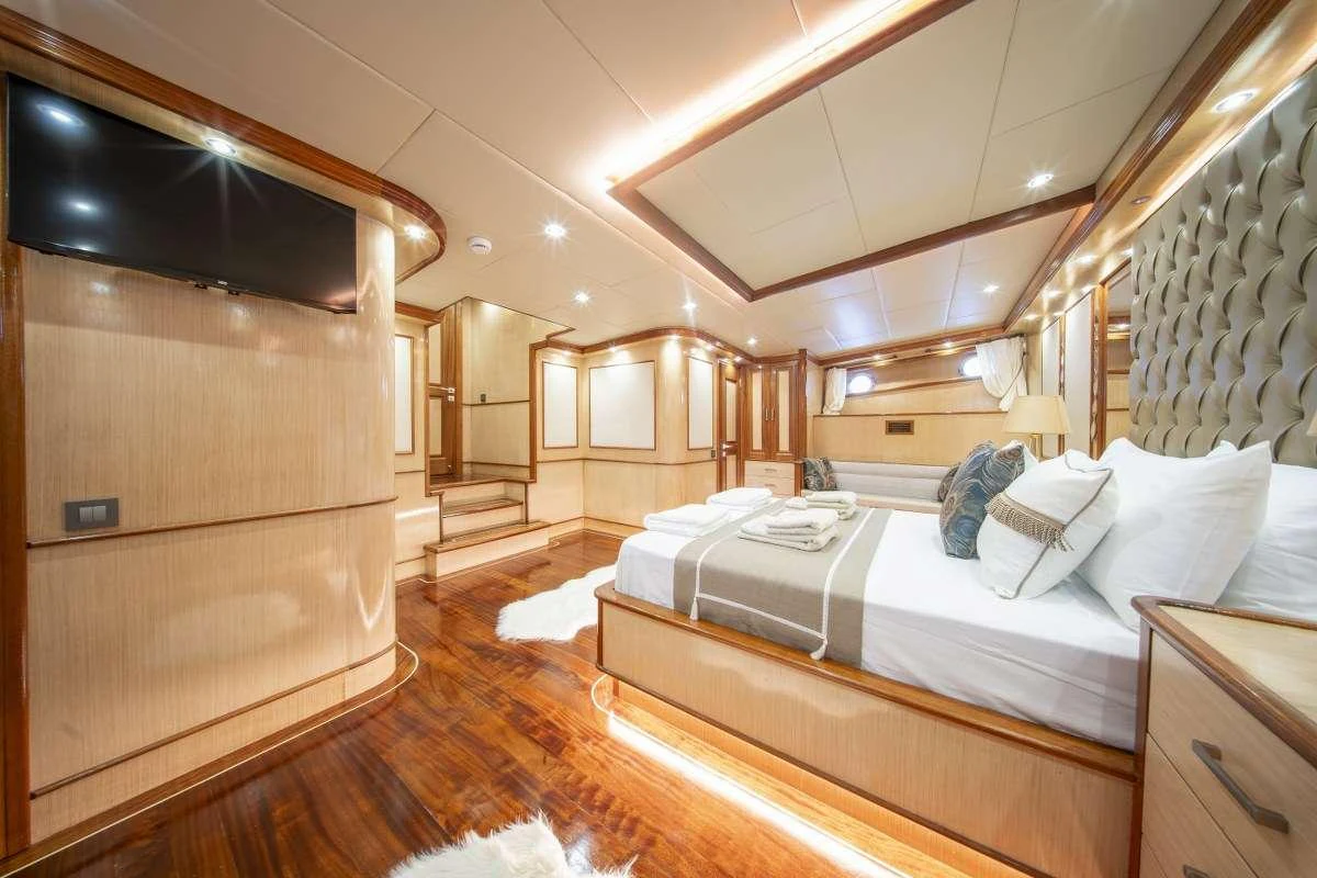a room with a bed and a wood cabinet aboard KAAN AYAZ Yacht for Charter