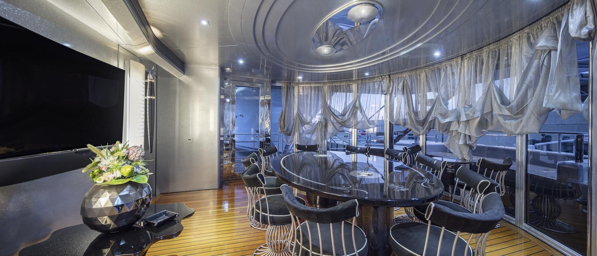 a room with a table chairs and flowers in it aboard THUNDER Yacht for Sale