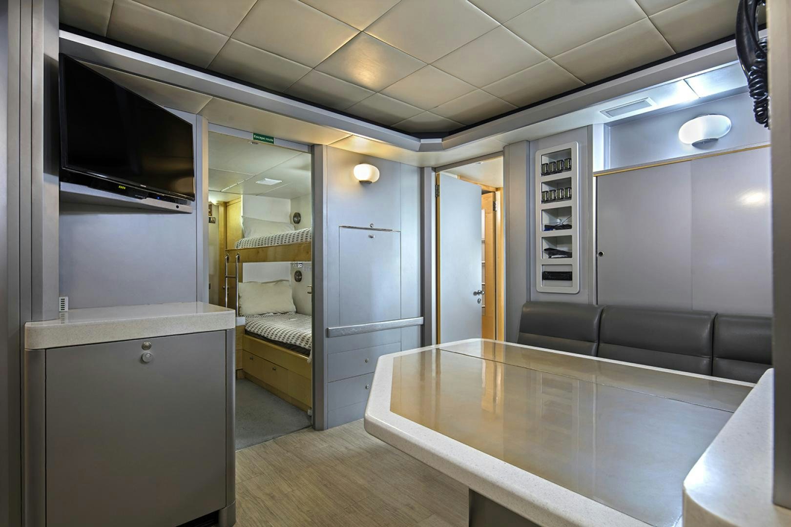 a room with a bed and a desk aboard THUNDER Yacht for Sale