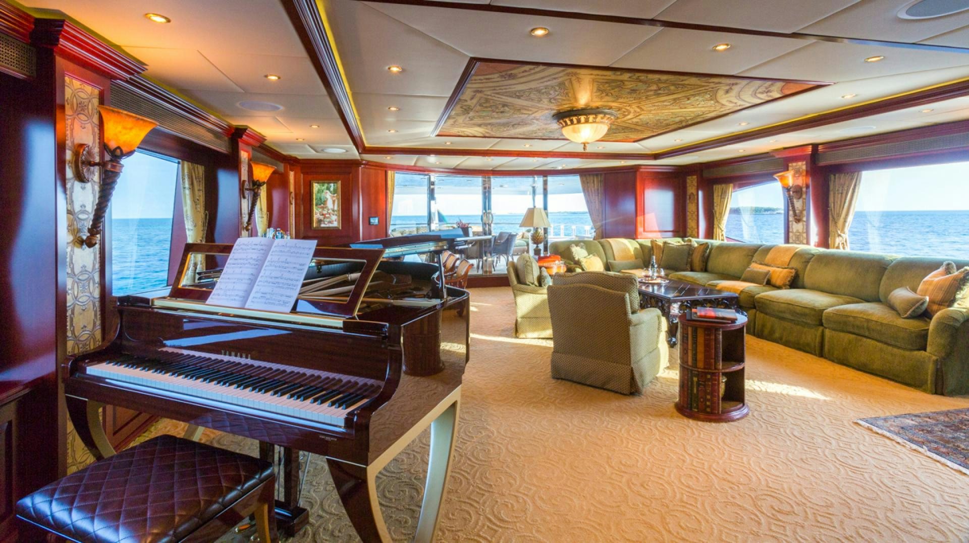 a large room with a piano and a couch aboard AMARULA SUN Yacht for Sale